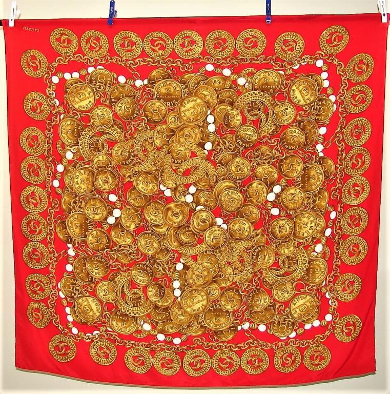 Oversized Chanel Scarf 53.5" x 52.5": Red silk chiffon base with gold Coco Chanel medallions, chains, and pearls. Some of the medallions are joined C's and the others are the Chanel address in Paris, various Chanel logos throughout