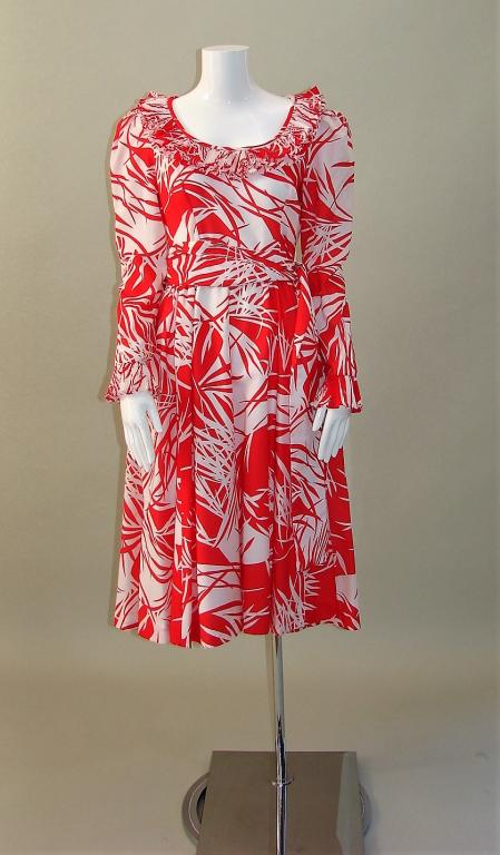 1970s Victor Costa Tropical Printed Dress: Victor Costa Ltd., size 16, red and white rayon, has a double accordion pleated ruffle at the collar and at the wrist, fully lined, comes with the original belt, darts in the bodice and gathers under 