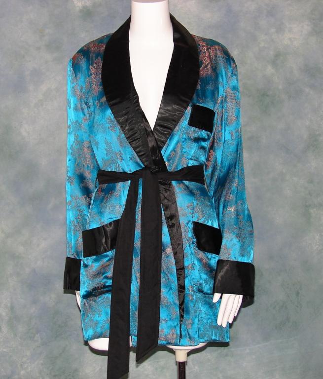 Vintage Chinoiserie Smoking Jacket: Blue Rayon fabric with gold and red patterned design, wide lapels, 3 pockets, original belt, lined in black Rayon, tag reads Oriental Made In China sz 42 100% Rayon 34" L x 22" across bust