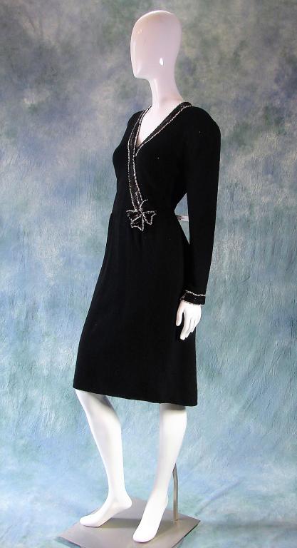 Designer Knit Dress with Sequin Details, 1980: Don Sayres for Wellmore sold at Bullocks Wilshire, thick black knit with black sequin details at the wrists and around neckline ending with a bow at the waist, sequins outlined w/silver sequins, long 