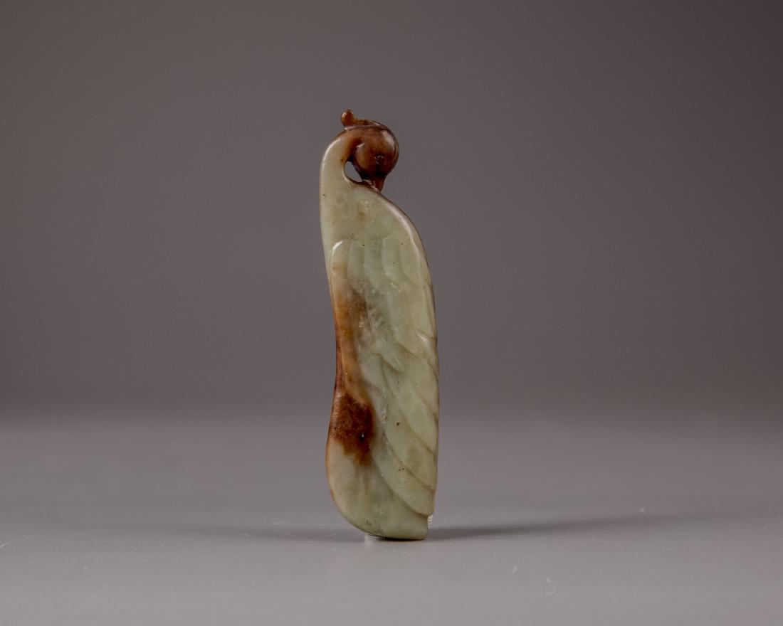 A Chinese celadon and russet jade carving of a peacock (1 of 2)