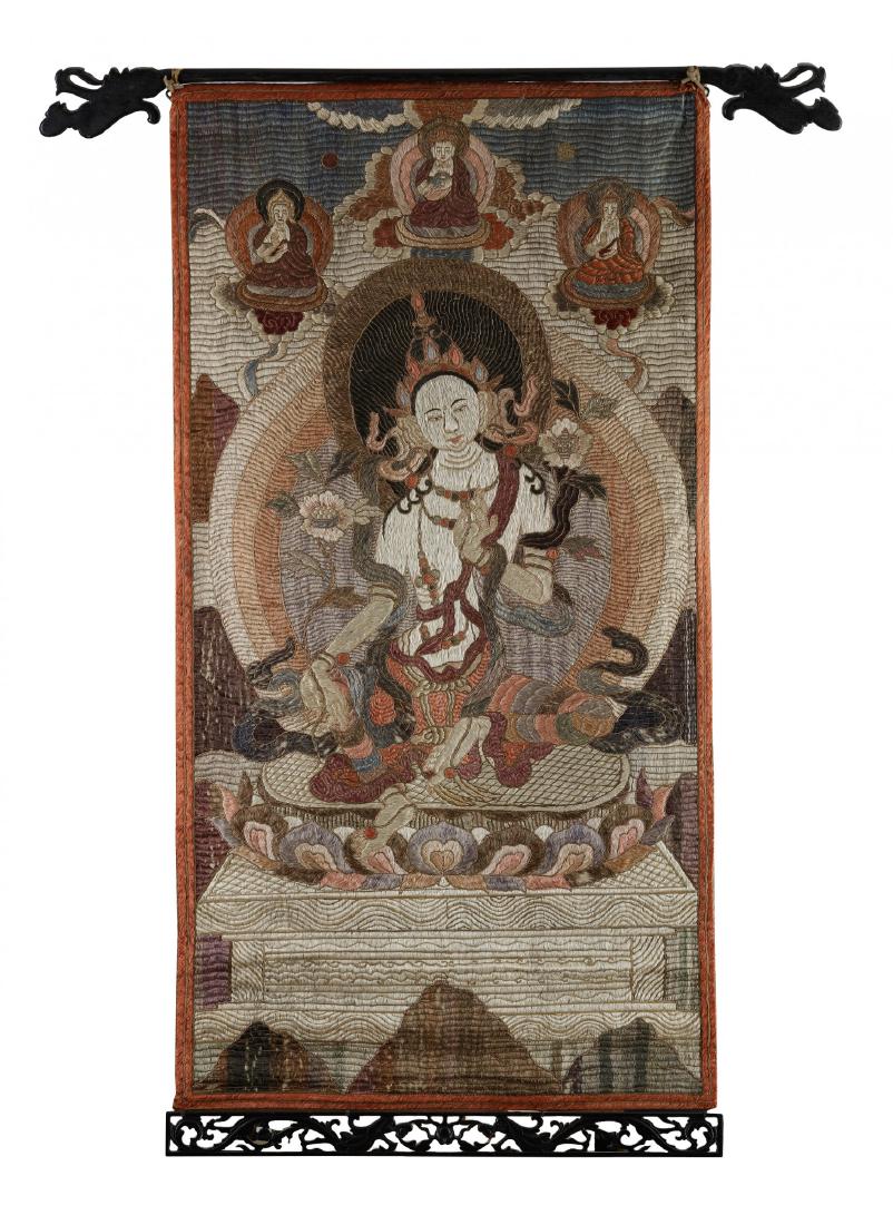 A Mongolian embroidered thangka of Green Tara: The thangka is embroidered depicting Green Tara seated on a single lotus throne, with both hands holding lotus stems, her left hand in abhayamudra and her right hand in varadamudra. She is depicted be