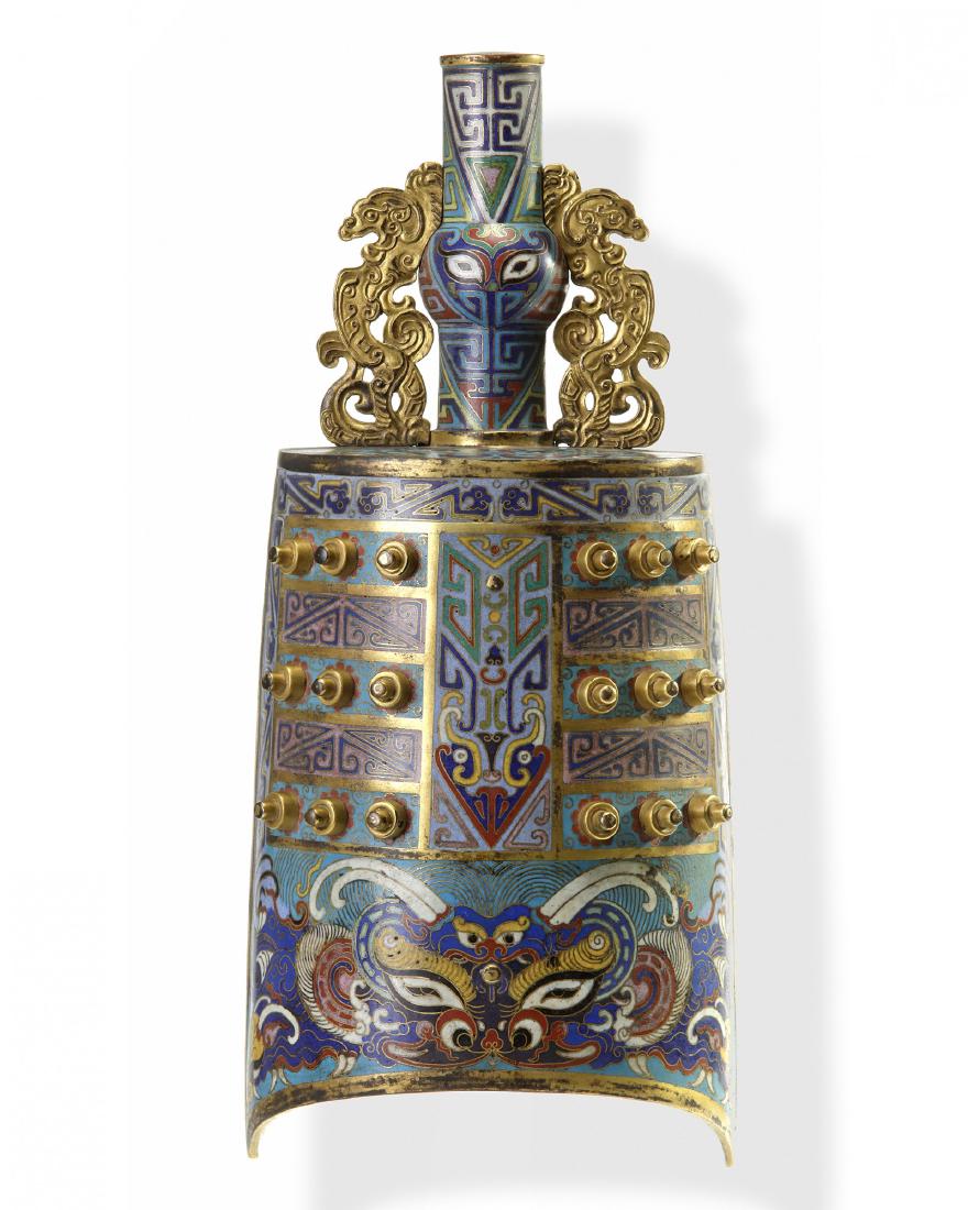 A Chinese cloisonne enamel bell, yongzhong: The bronze is crafted in lenticular form, decorated with archaistic motifs including large taotie masks at the bottom above the arched rim. The central trapezoidal panel is inset with eighteen bosses 