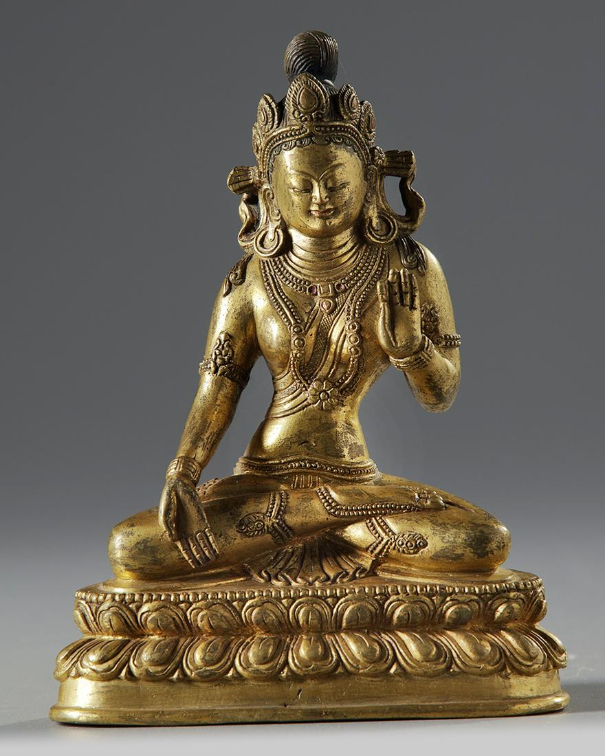 A Gilt Chinese figure of Bodhisttva: Seated on a double lotus base with bearded edges, the right hand raised and holding an attribute. Origin: China Period: 19th century Sizes: 16.50 cm. H 6.5 in. H