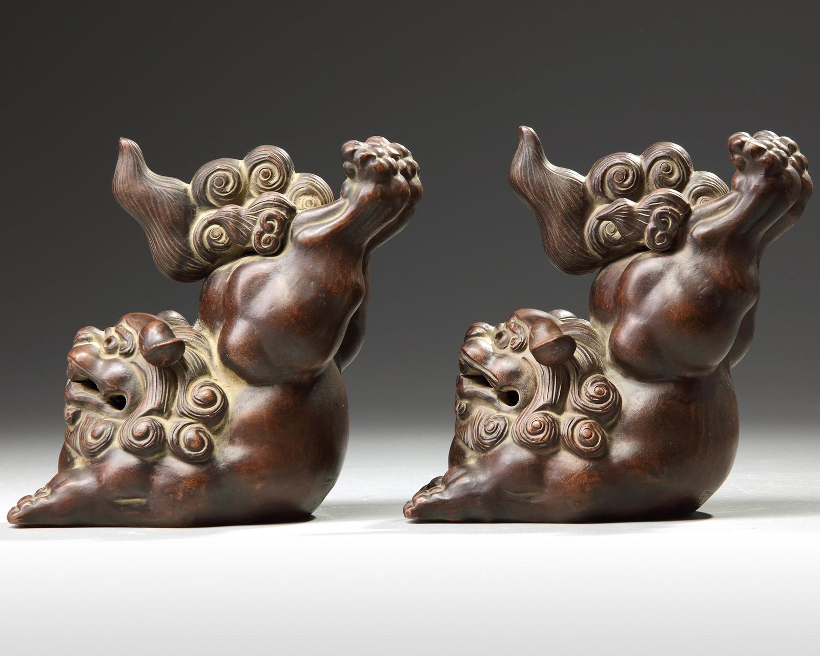 A PAIR OF CHINESE YIXING STONEWARE JUMPING BUDDHIST: Set of two Chinese Yixing stoneware jumping Buddhist lions throwing their hind legs in the air by the contemporary Yixing master Li Jun (1967), at the back sealed: Lu, Lu Jun zhitao (â€˜Ceramics m