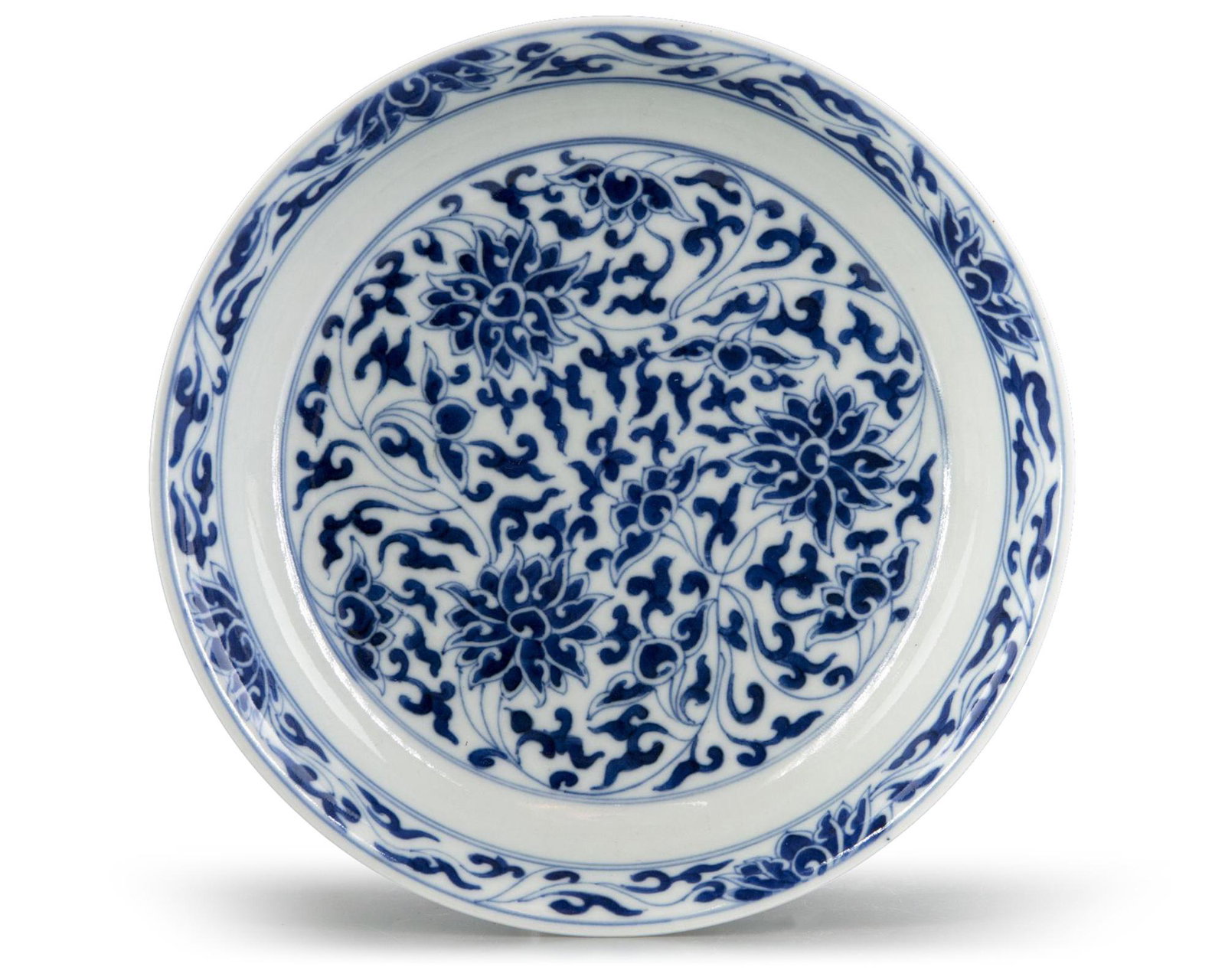 A CHINESE BLUE AND WHITE 'LOTUS' DISH, 19TH CENTURY: The dish with slightly flaring sides, decorated with a central medallion of scrolling lotus, surrounded by an undecorated band and a further lotus band to the rim. The exterior is similarly decorated 