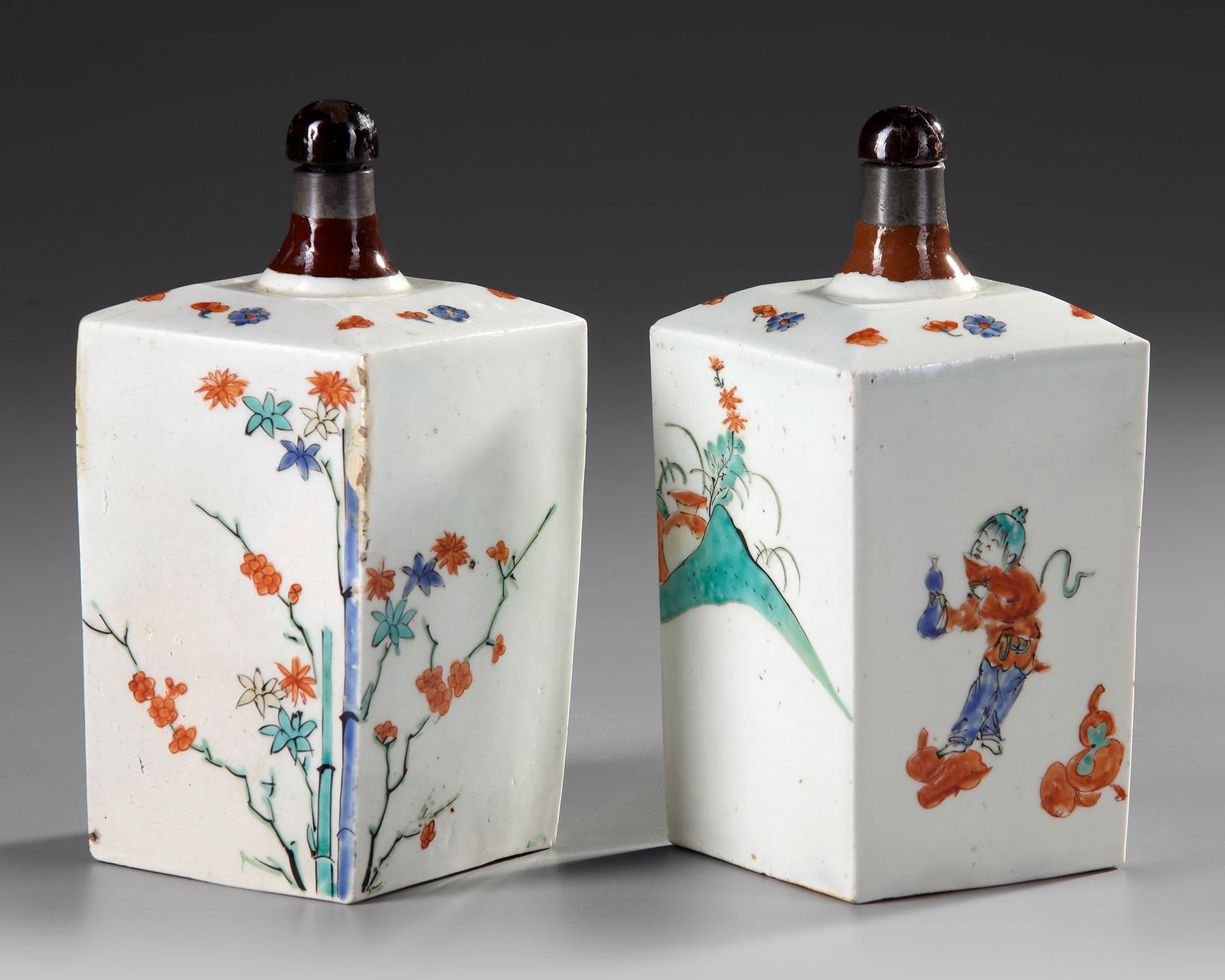 A PAIR OF JAPANESE KAKIEMON SAKE FLASKS, EDO PERIOD, LATE 17TH CENTURY: Two Japanese rectangular bottles with small tapering neck-rim and canted shoulder, the shoulder decorated with flower heads, decorated in iron-red, green, black enamels with bamboo, tree-peony and pin