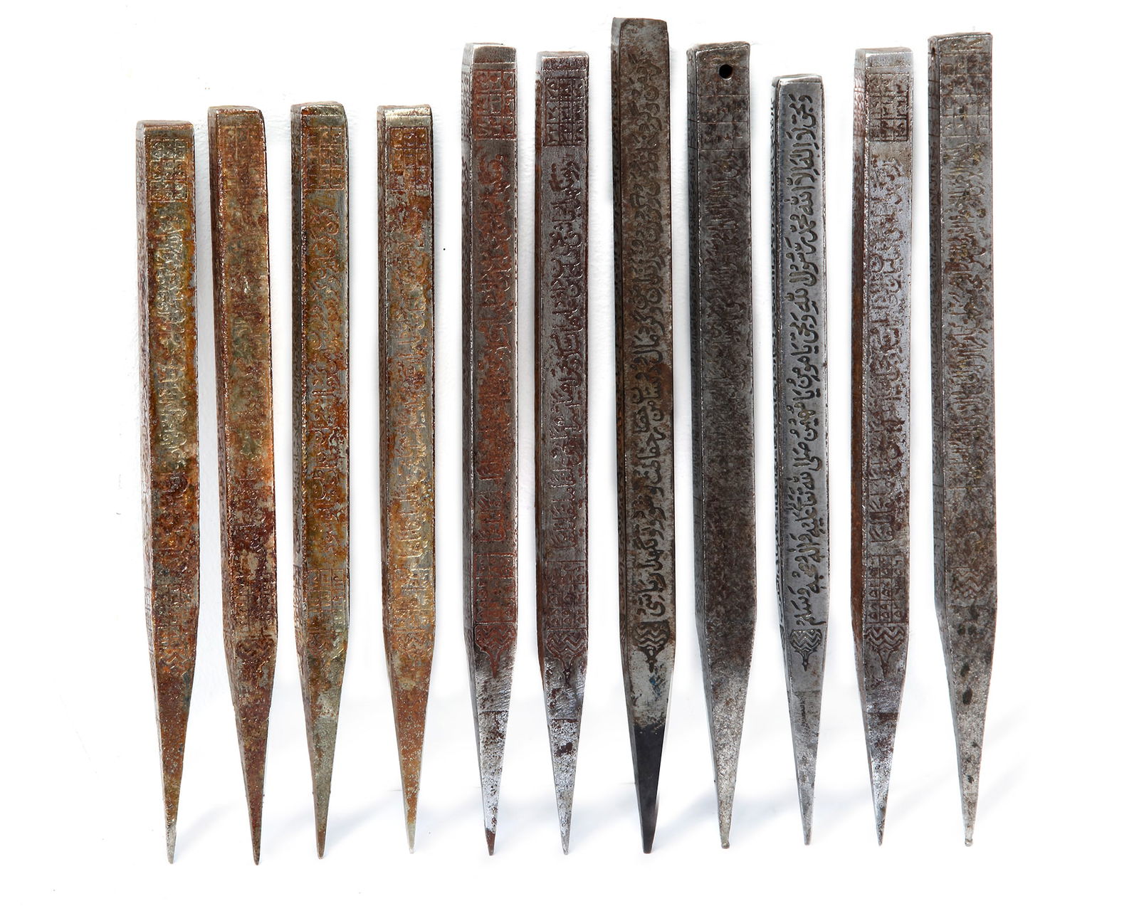 A PERSIAN SET OF ELEVEN INSCRIBED STEEL DIVINATION RODS, 19TH CENTURY: Each of faceted form, inscribed to each face with verses from the Quran and a domed design. The length varies from 18 to 22.2 cm.