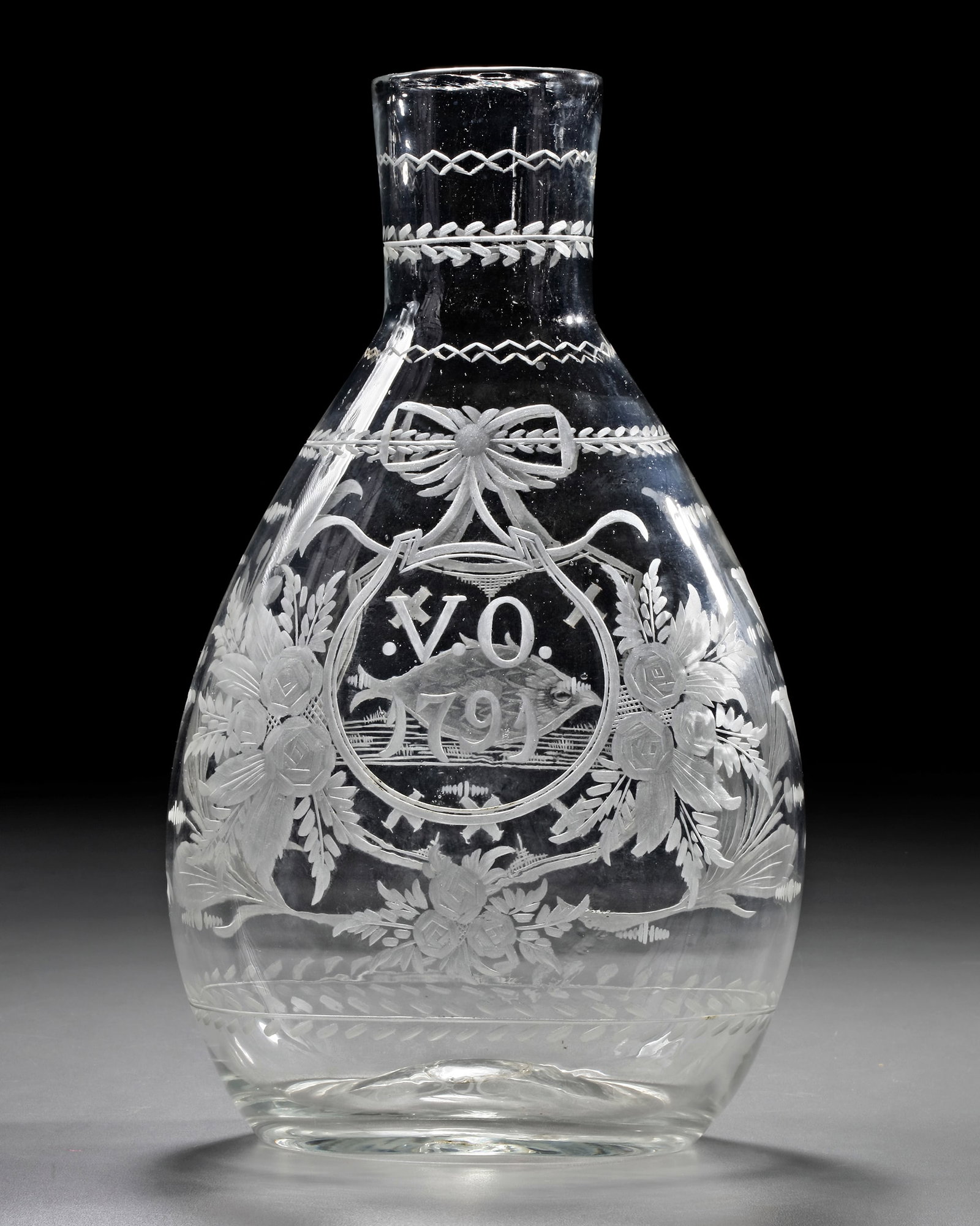 A POSSIBLY DUTCH ELABORATELY ENGRAVED WHITE GLASS CARAFE, DATED 1791: Engraved with foliage, garlands and a shield with an unidentified coat of arms depicting a fish set between crosses,verso dated V.O.1791, height: 26 cm.