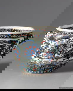 A KUTAHYA POTTERY BOWL, TURKEY-KUTAHYA, 19TH CENTURY: The bowl, with two small handles, is decorated with two bands of flower scrolls and foliage. Height 8 cm. Diameter 9.5 cm.