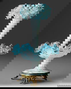 AN OPALESCENT GLASS VASE, 19TH CENTURY: This elegant 19th-century epergne is crafted from opalescent glass, featuring a stunning blend of white and light blue hues. The design showcases a central fluted trumpet vase with delicately ruffled