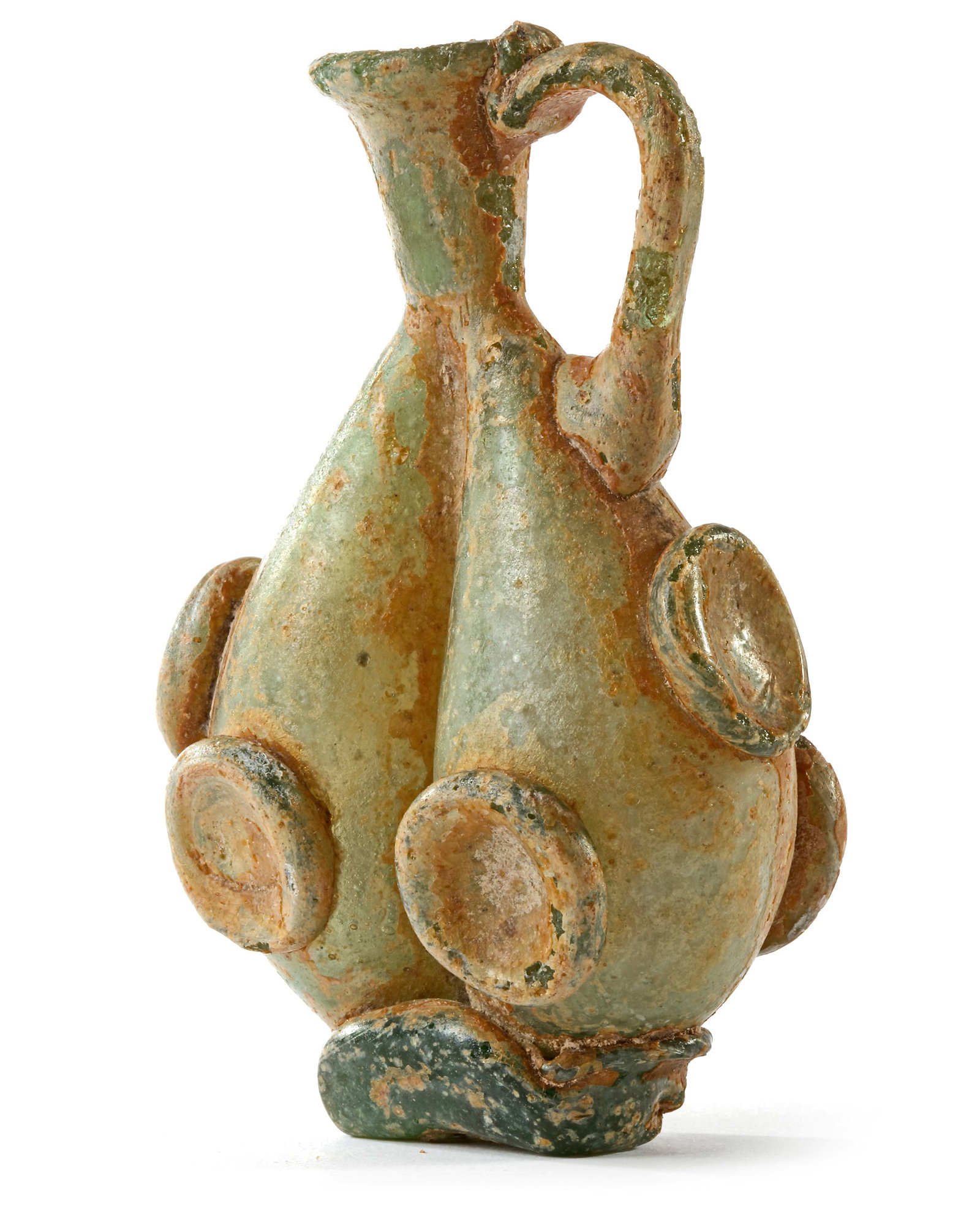 AN EARLY ISLAMIC GLASS FLASK, NEAR EAST, CIRCA 8TH-10TH CENTURY: Into two parts with yellow-green tinge, and applied roundels. Intact. Height: 9 cm.