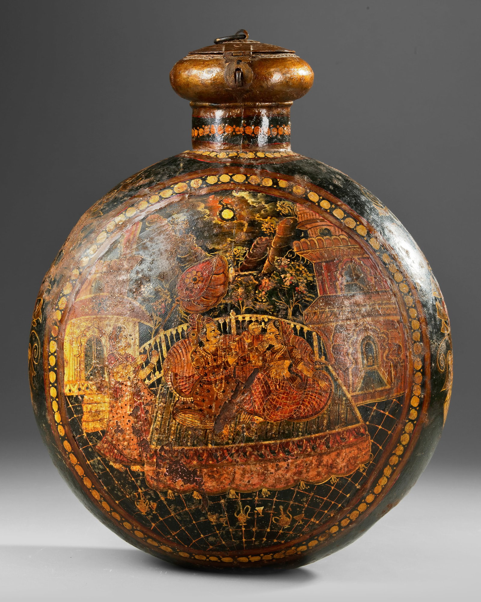 A LARGE MUGHAL PAINTED METAL PELGRIM'S FLASK, INDIA, 19TH CENTURY: A large Indian metal flask with a cork stopper, painted on both sides with roundels enclosing a scene of a Mughal prince enjoying a drink with his wife and servants on a terrace. 48 by 37 by 22 cm.