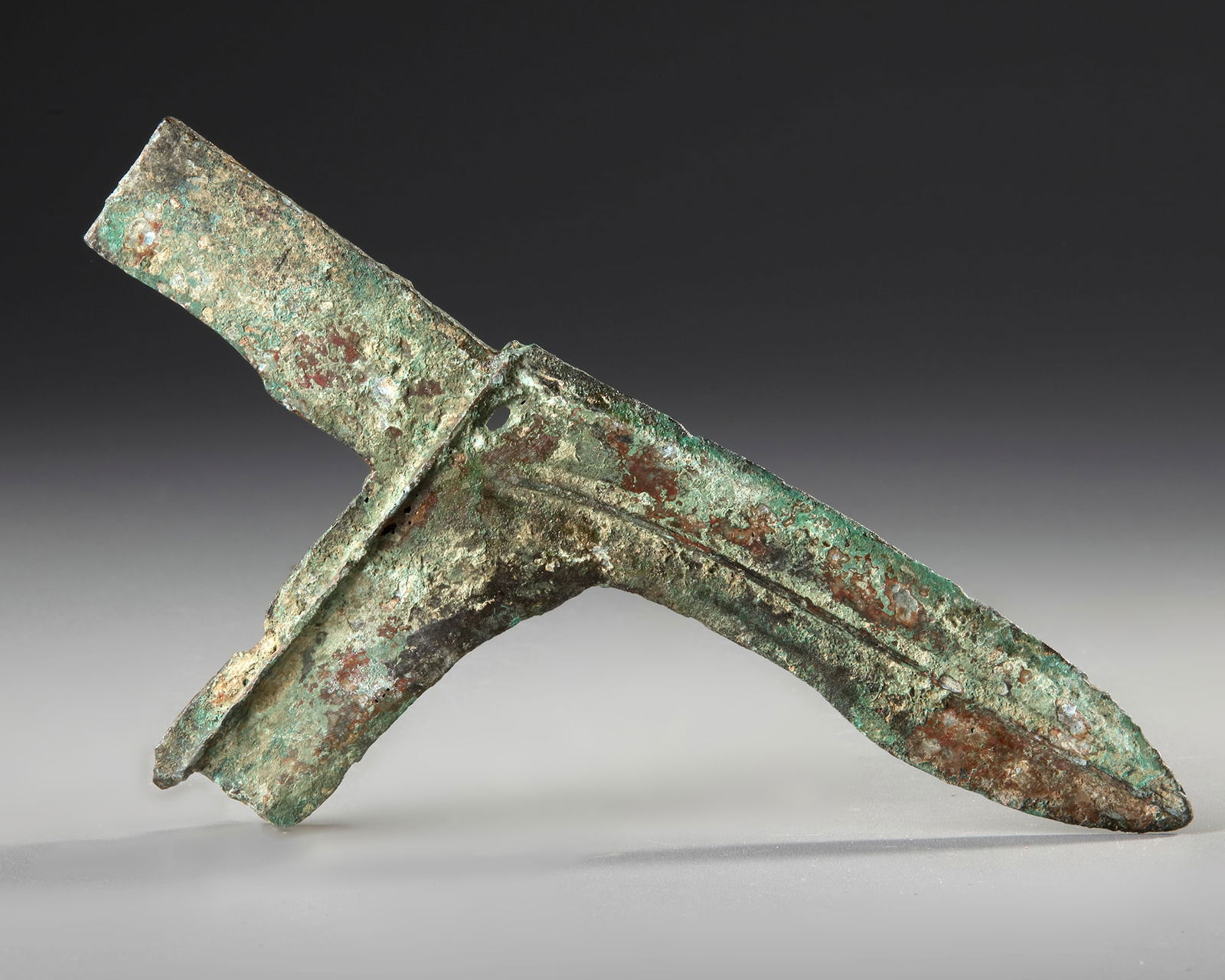 A CHINESE BRONZE DAGGER AXE, GE, EASTERN ZHOU (770-256 BC) AND LATER: Cast with the elongated yuan divided by a raised ridge in the middle of each side and extending downward to form the hu.Length: 22 cm