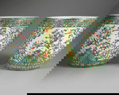 A PAIR OF CHINESE FAMILLE VERTE  JARDINIERES, 19TH/20TH CENTURY: Heavily potted, each decorated in famille verte enamels with panels enclosing a bird perched amid blossoming branches, beneath a band of ruyi heads filled with flowers and above a border of plantain l