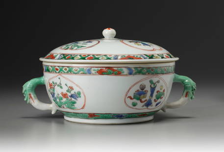A CHINESE FAMILLE VERTE TUREEN AND COVER, KANGXI PERIOD (1662-1722): The tureen is of circular form with animal head handles, the exterior is decorated with leaf-shaped panels enclosing flowers below a floral border. The domed cover is similarly decorated and is surmou