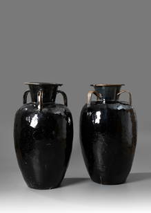 A LARGE PAIR OF CHINESE EARTHENWARE VESSELS, 19TH CENTURY: Of ovoid shape with flaring rim and three loop-handles to the shoulders, decorated with a black glaze, the handles with a brown glaze. Height 89 cm.