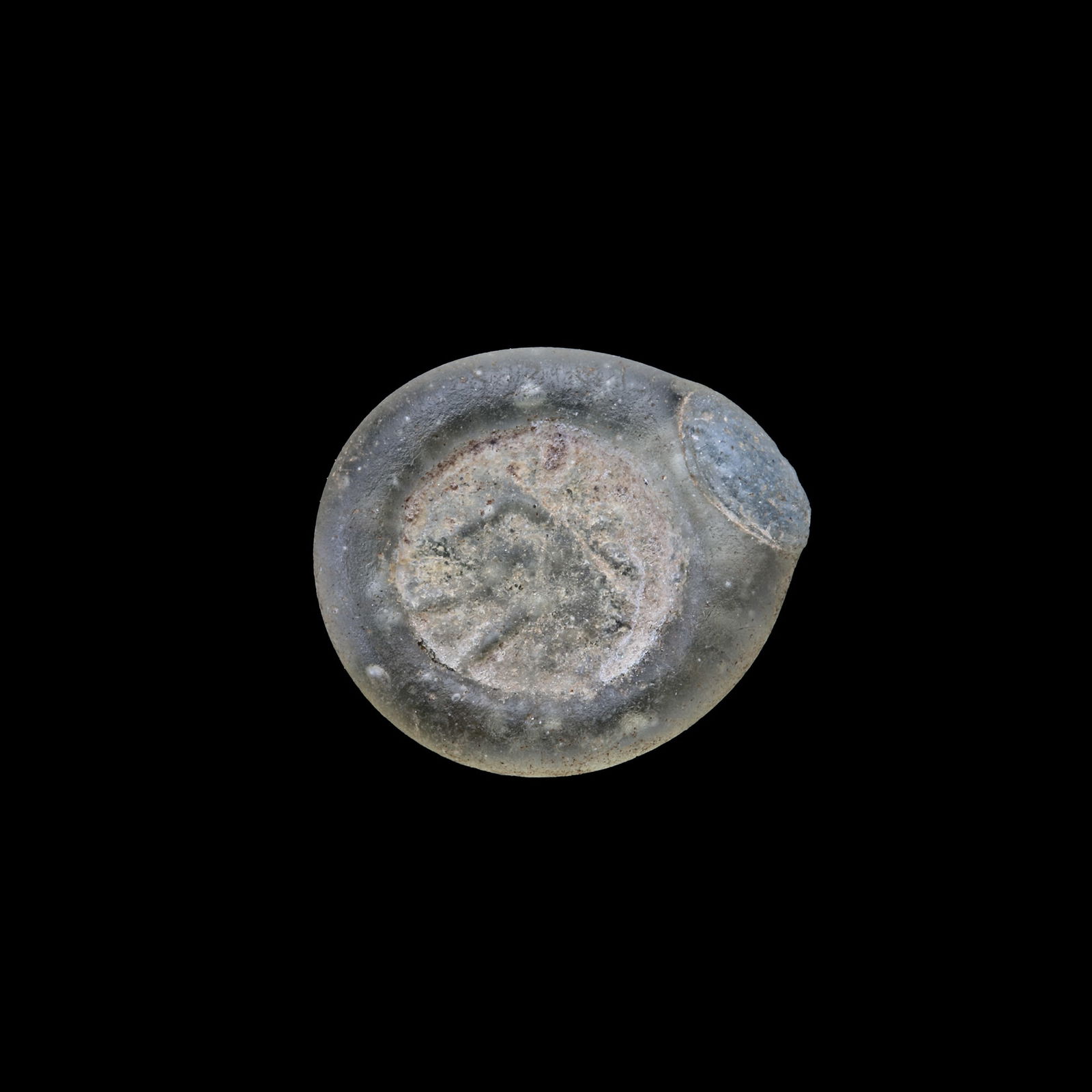 AN EARLY ISLAMIC GLASS WEIGHT OF HALF DIRHAM, 10TH-11TH CENTURY: Glass weight, moulded and stamped, transparent greenish-white in colour, citing in the centre with " the word Kaa". 1.478 g., 16 mm. coin weight: half dirham.