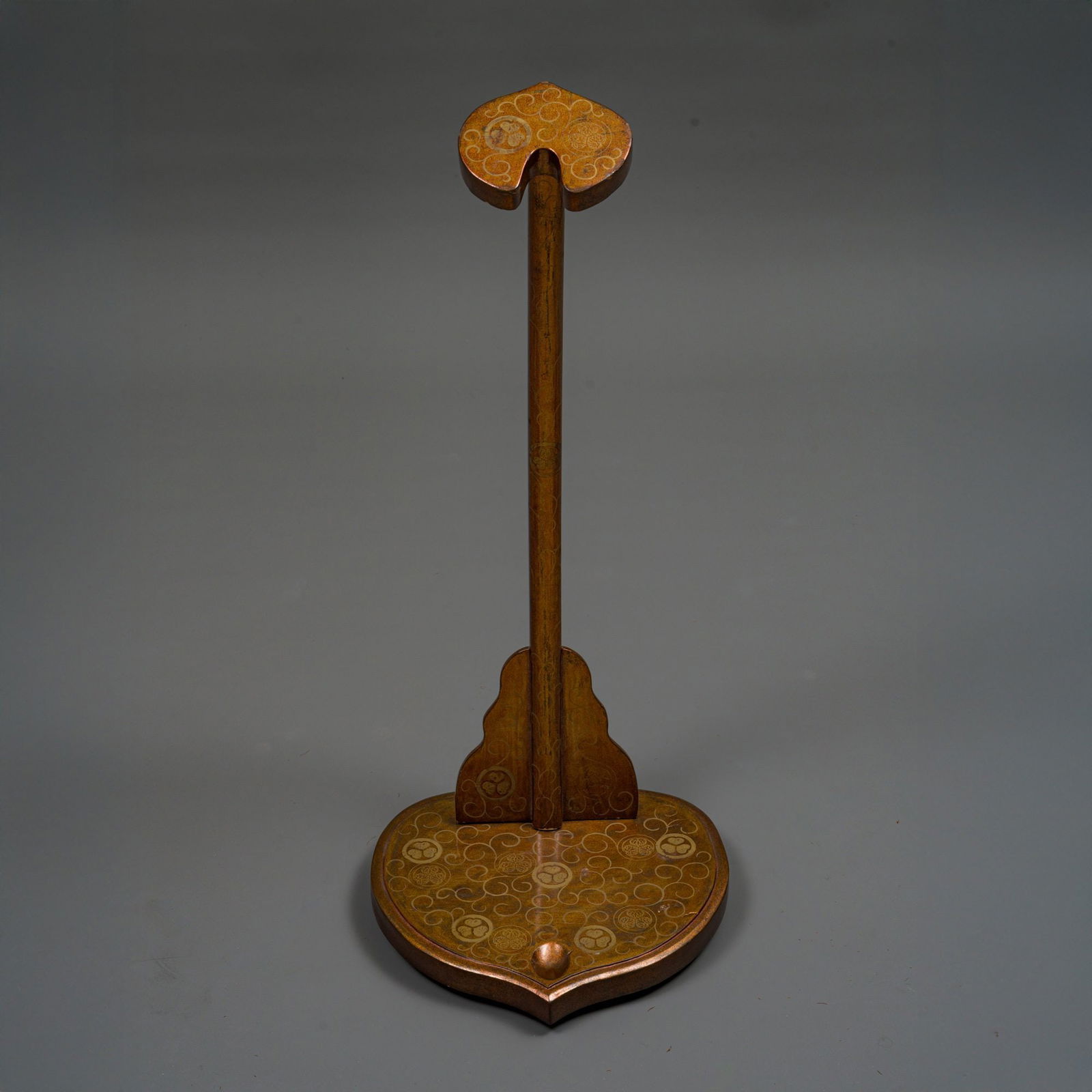 UPRIGHT GOLD LACQUER KATANA STAND TACHI’KAKE ???: A lacquered wooden upright katana stand tachi’kake ???, decorated with an elegant scrolling foliage design that envelops crests of the Tokugawa clan: the iconic mitsuba aoi ????? (three hollyhock le