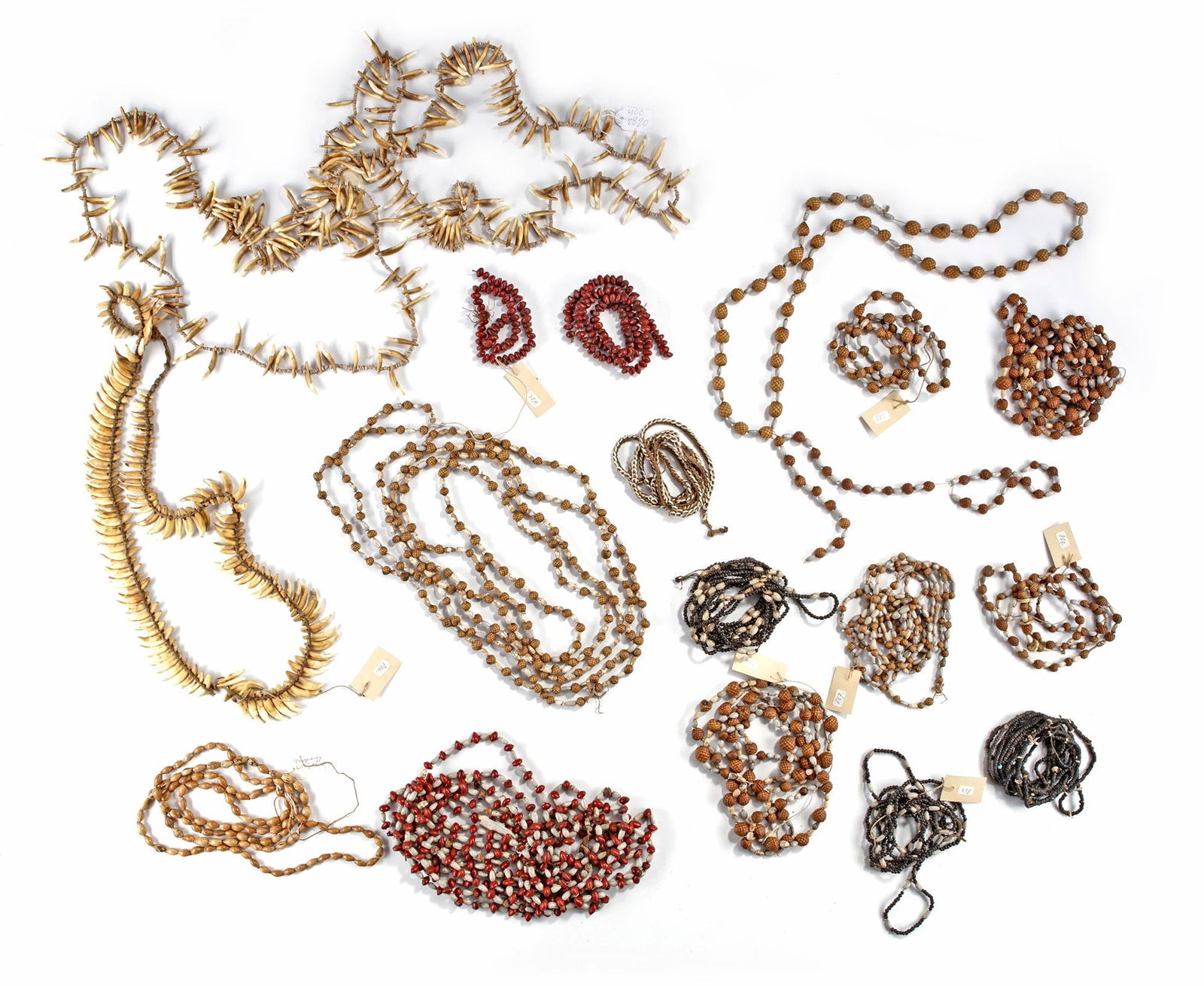 A collection of neclaces from Papua New Guinea.: Among others a dog tooth necklace. Collected by Jac Hoogerbrugge in the 1960’s or 1970’s. Herewith a long brides price necklace from Boiken consisting of dog teeth and conus shell beads. P