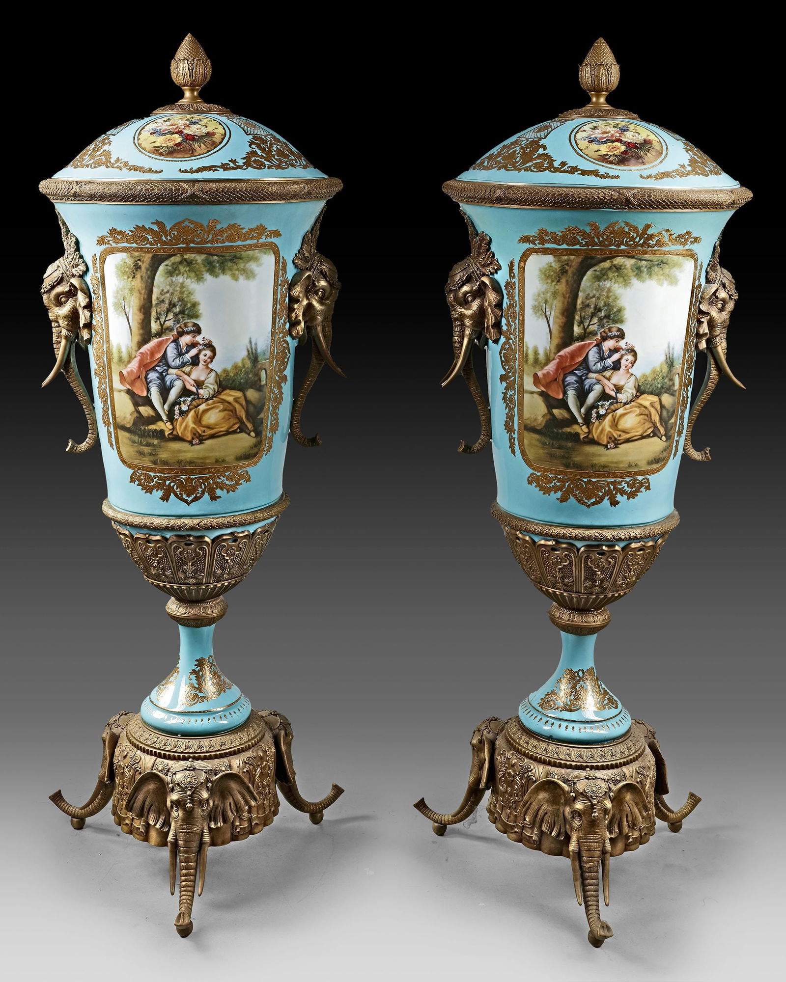 A PAIR OF LARGE SEVRE STYLE ELEPHANT HEAD VASES, 20TH CENTURY: Turquoise background, golden decoration of scrolls and flowers. Rch bronze ornamentation. Elephant head handles. Medallions painted with gallant scenes, in the style of François Boucher, and flowers