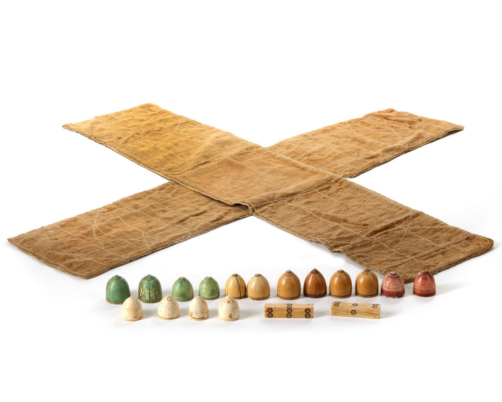 AN INDIAN PACHISI SET, 17TH CENTURY: Comprises sixteen domed pieces (narads) and two long dice (usually called pasas). The pieces are of characteristically dome-shaped solid bone, engraved at the top with circular grooves which hold red,