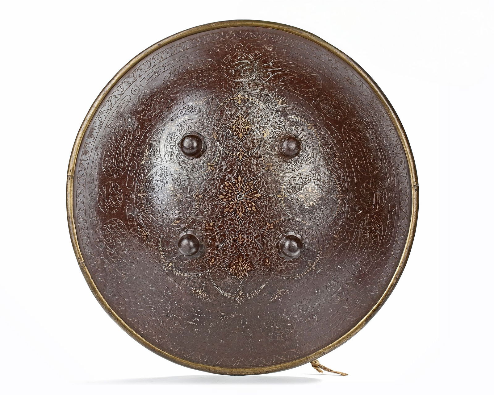 A QAJAR GOLD-DAMASCENED STEEL SHIELD, PERSIA, 19TH CENTURY: The shield with four applied bosses, the finely carved decoration with a central roundel with cartouches and roundels filled with floral leafy sprays, surrounded by a large diaper band containing