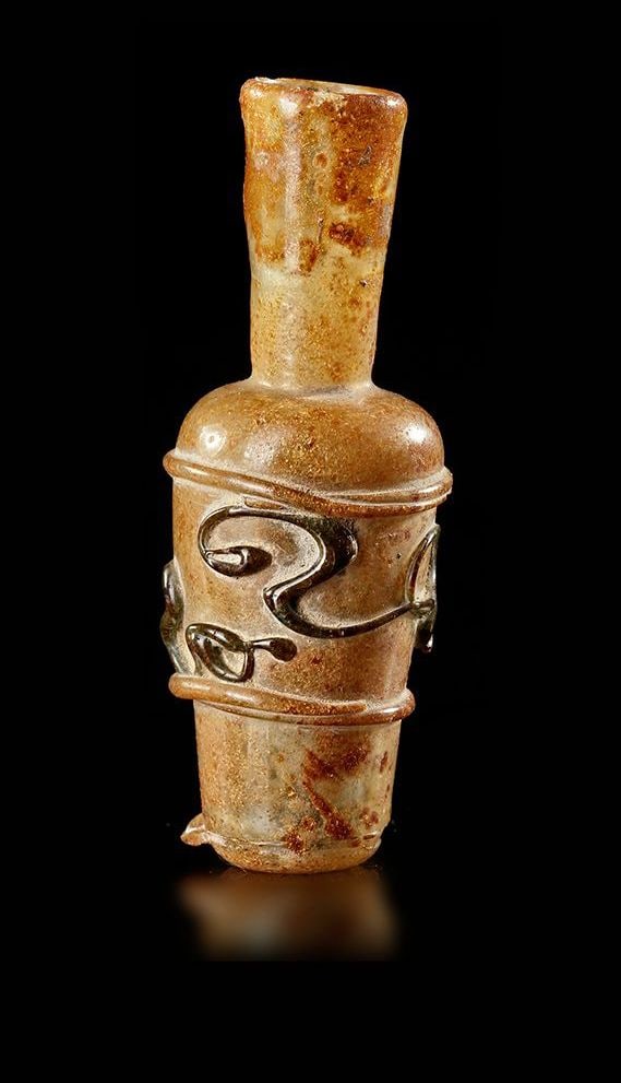 A SMALL BOTTLE WITH NET DECORATION, PERSIA, 11TH-12TH CENTURY: Small bottle with truncated cone-shaped body and long neck, in colorless translucent glass with applied decoration of three fillets of the same hue framing the body and emphasizing the base, and