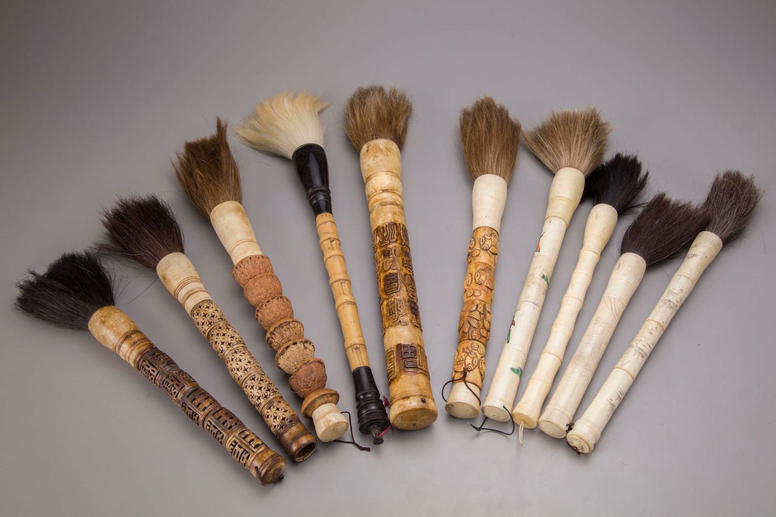 TEN CHINESE CALLIGRAPHY BRUSHES: Horse hair with carved bone, walnut and bamboo handles.50.5 cm. and smaller.