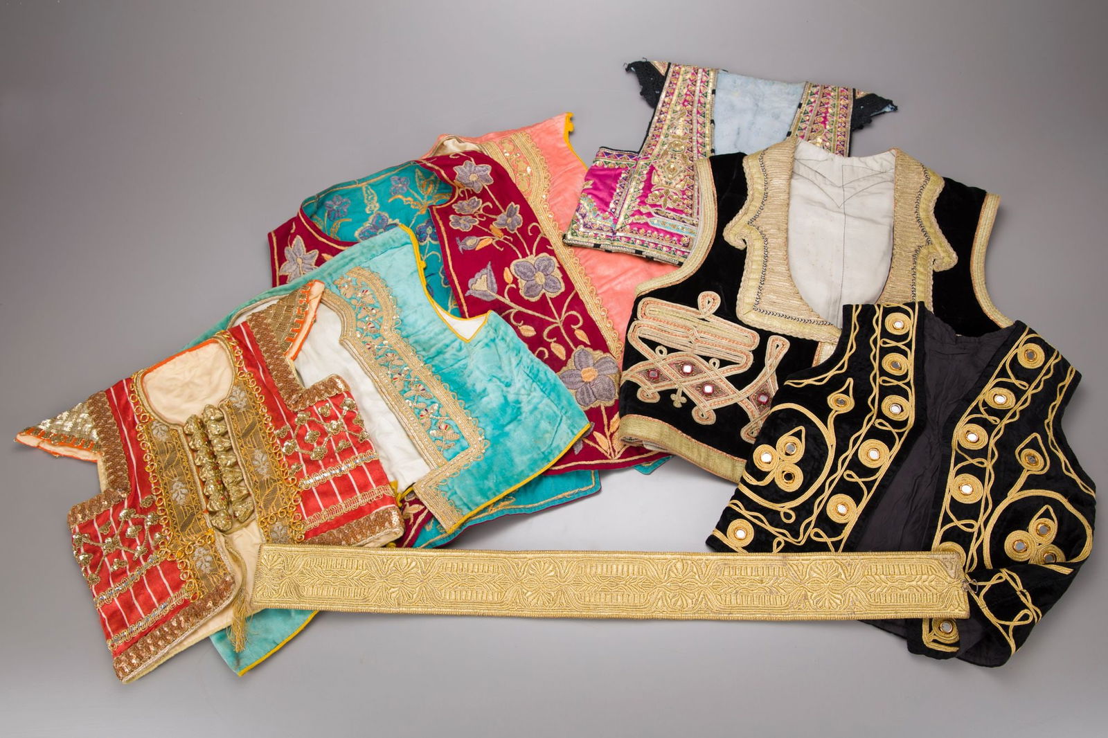 SEVEN OTTOMAN WAISTCOATS AND A BELT, 20TH CENTURY: Of velvet embroidered with metal thread.