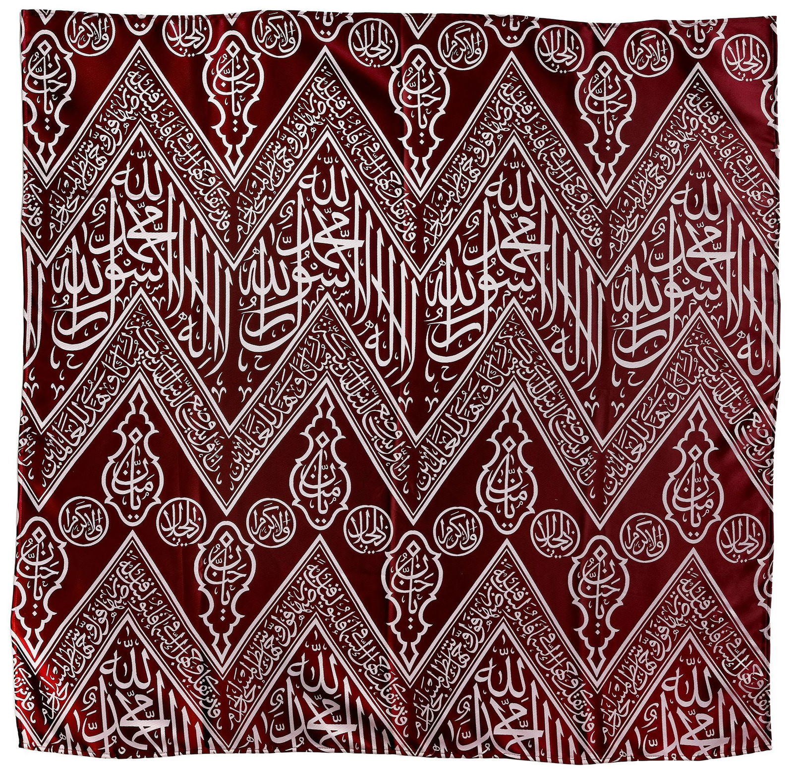 AN OTTOMAN RED EMBROIDERED SILK KISWA, 20TH CENTURY: A fragment of the inner curtain of sacred kiswa for the inner wall of the Kabaa with an inscribed weave in cream-colored silk over a dark red ground. The crests of the chevrons are embellished with la