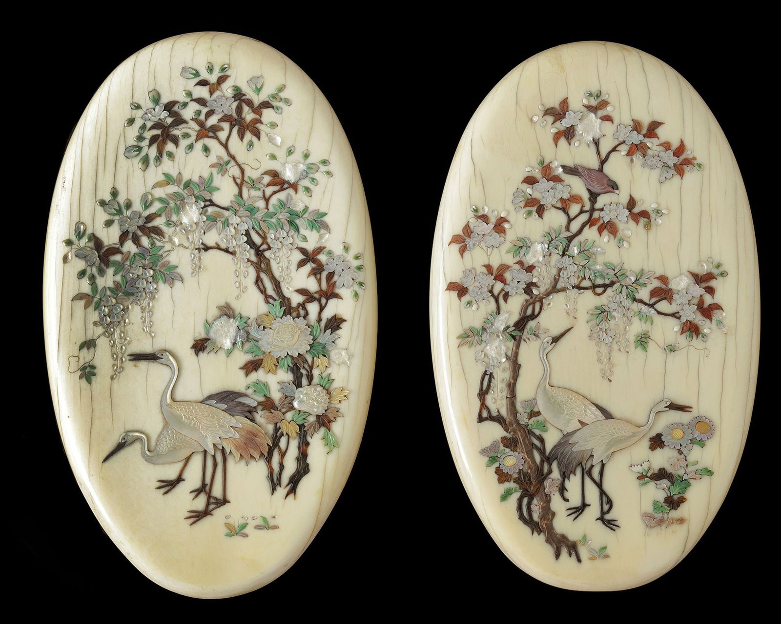 A PAIR OF JAPANESE OVAL-SHAPED, MOTHER-OF-PEARL INLAID CRANES PLAQUES, MEIJI PERIOD (1868-1912): 13 by 8 cm.