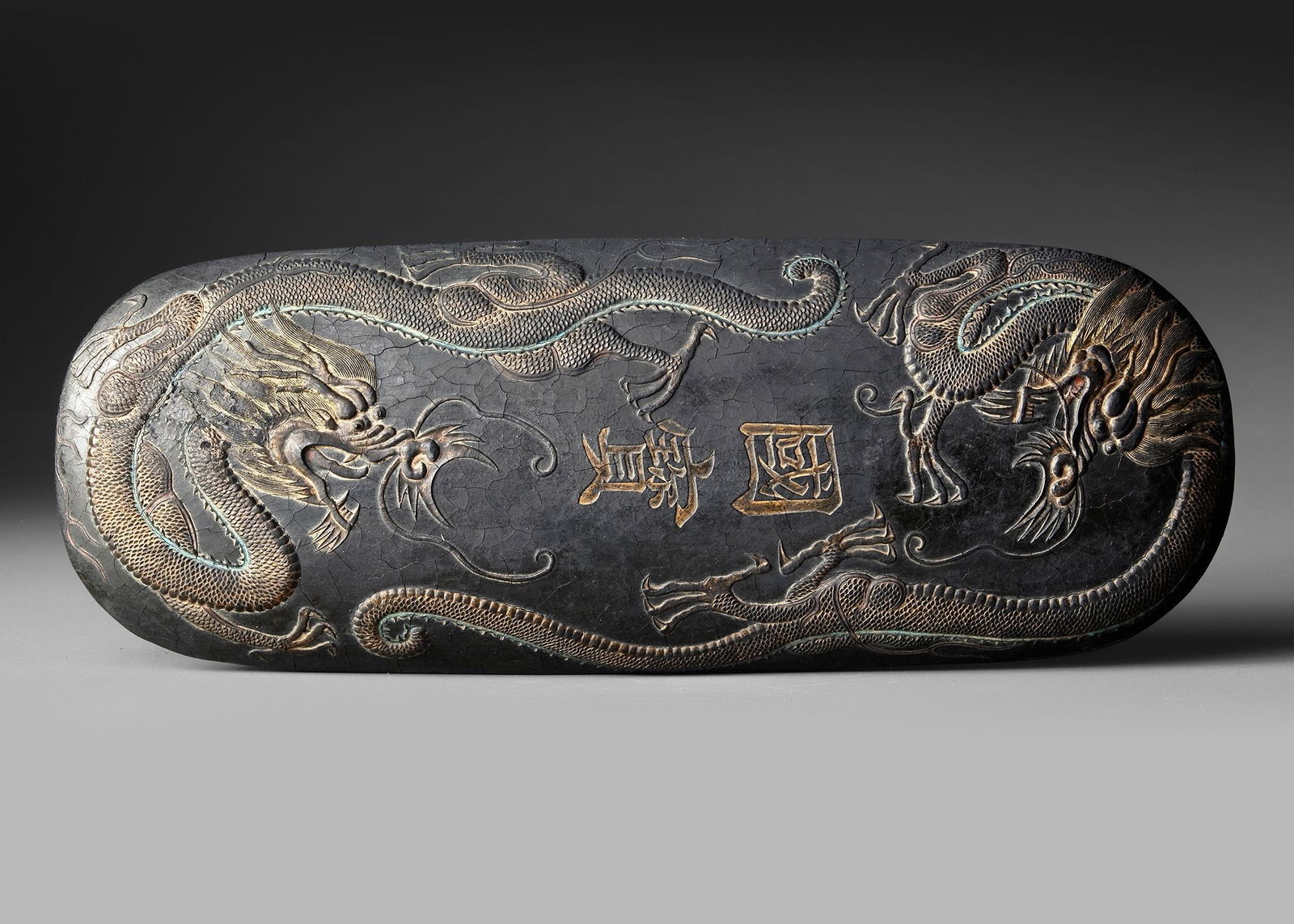 A CHINESE INK BLOCK, MING DYNASTY (1368-1644): WITH XUANDE MARKA finely carved ink block , richly decorated with dynamic dragon motifs in relief. The dragons are shown twisting among clouds, symbolizing power, authority, and imperial auspices in t