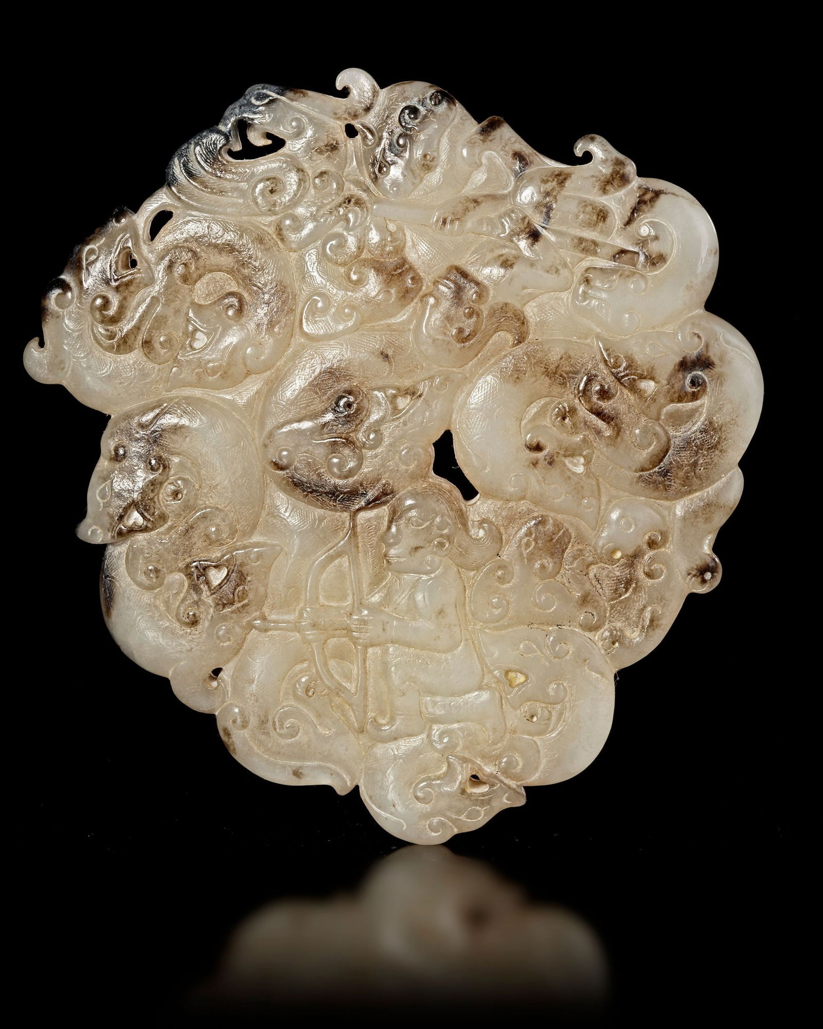 A JADE PENDANT, CHINA, HAN DYNASTY (206 BC-220 AD): A finely carved white jade pendant featuring a circular composition surrounded by numerous stylized mythical creatures and flowing cloud motifs. At the center appears a human figure holding a bow, ren
