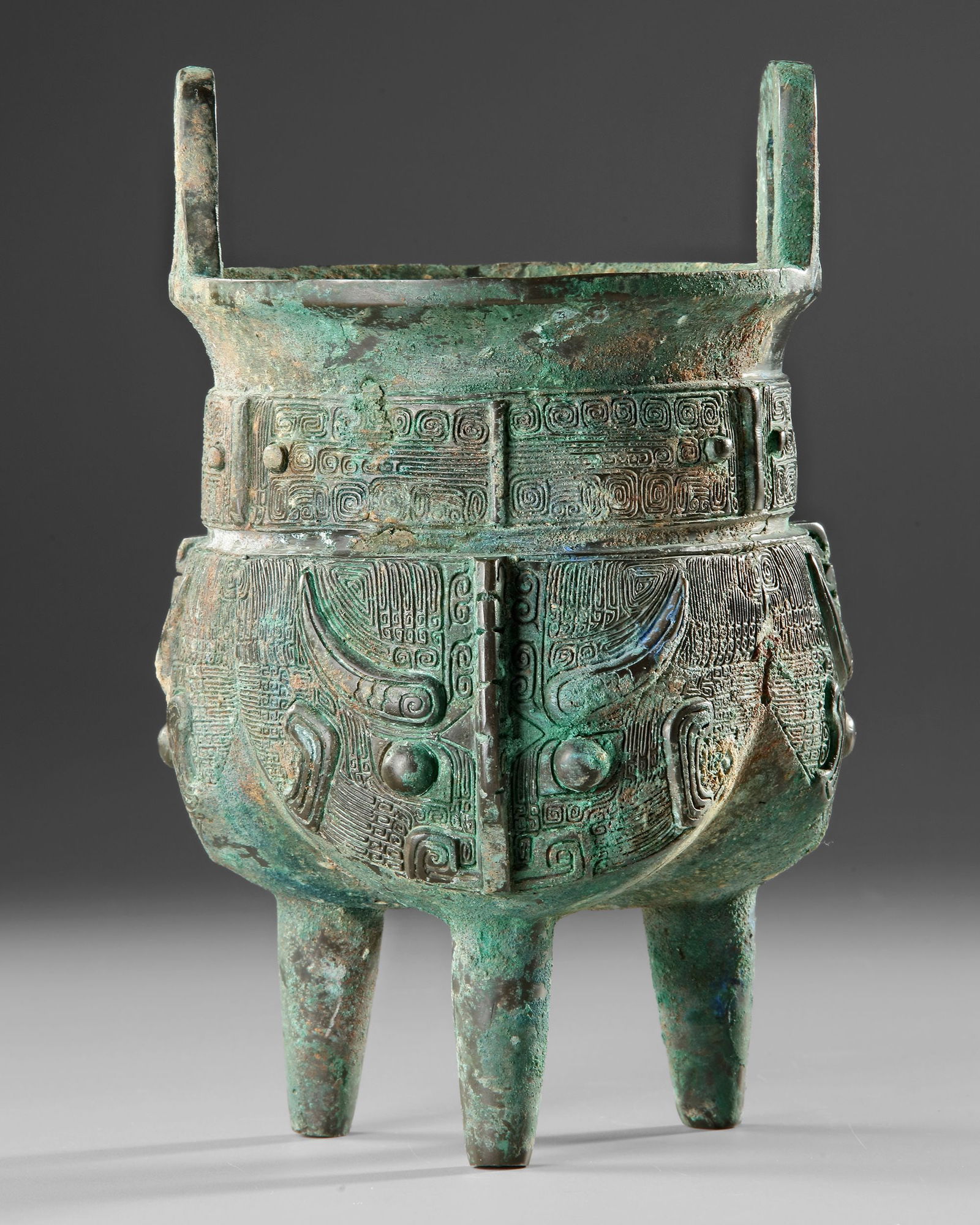 A BRONZE RITUAL VESSEL, CHINA, ZHOU DYNASTY: Period: Zhou Dynasty (c. 1046-256 BCE)An impressive bronze liding ritual vessel from the period of the Zhou Dynasty. Tripod vessels of this type were used in ancient Chinese ceremonies for preparing a
