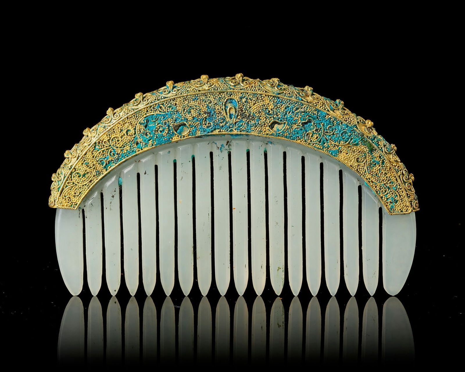 A COMB WITH CHINESE JADE AND BRONZE ORNAMENT, CHINA, LIAO DYNASTY (907â€“1125): Elegant ceremonial comb composed of a finely carved pale comb body, surmounted by a richly decorated Chinese bronze mount The curved bronze crest is intricately ornamented with delicate filigree scrol