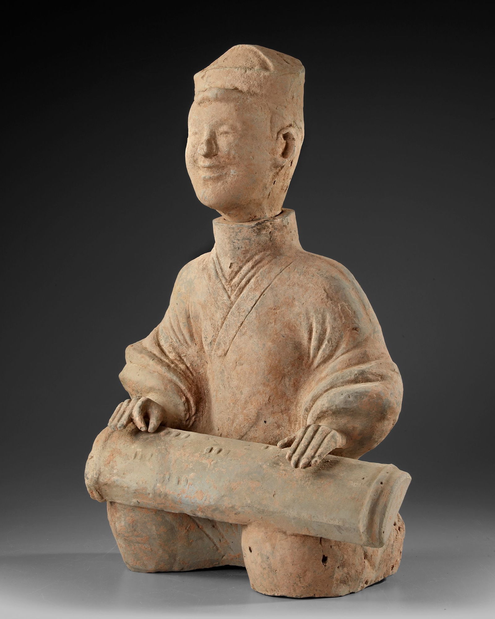 A RARE TERRACOTTA STATUE OF A SITTING MUSICIAN PLAYING A ZITHER TYPE INSTRUMENT, CHINA, EASTERN HAN (1 of 3)