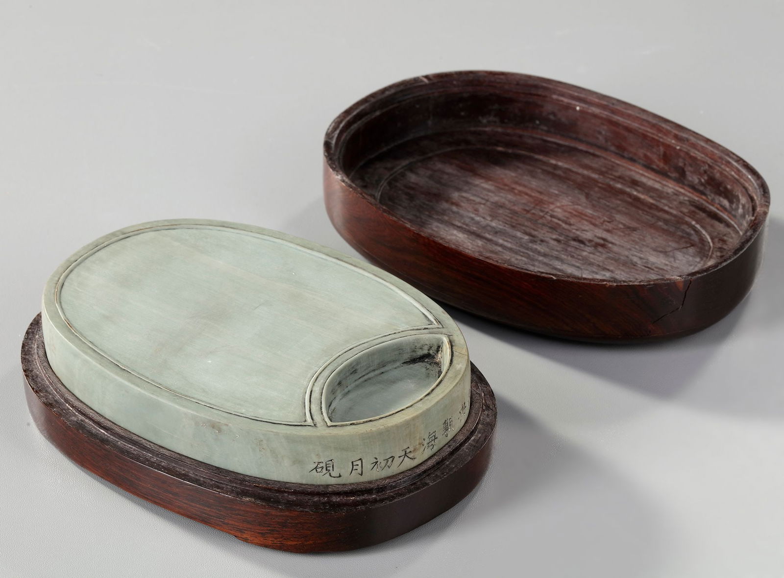 A CHINESE INKSTONE, 19TH CENTURY: A Chinese inkstone carved from green Duanxi-stone found in South-East Gaoyao County in Guangdong Province. 19.5 by 9.5 by 2.5 cm. Provenance: Private collection mr. J.K., Switzerland