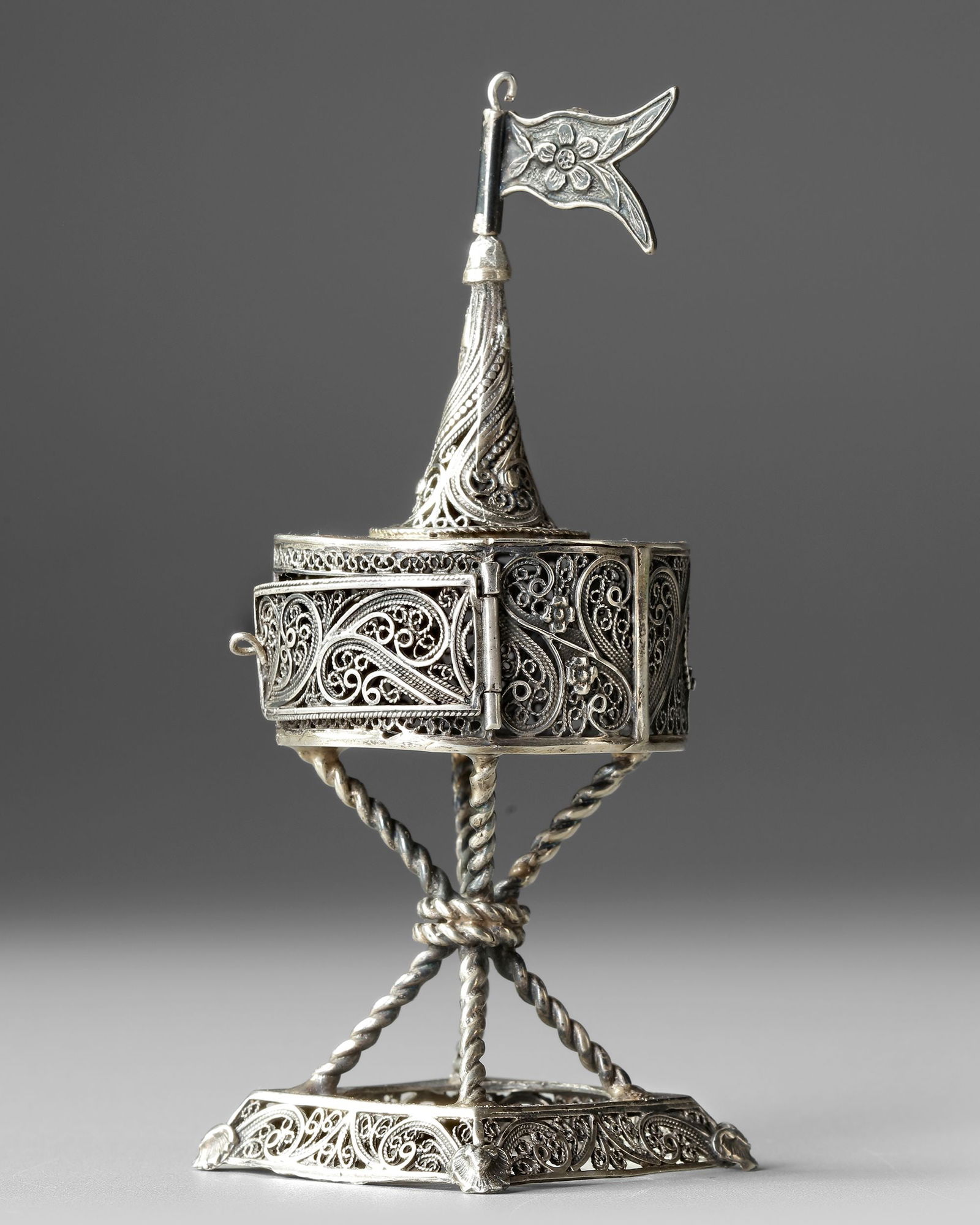 A SILVER OTTOMAN INCENSE BURNER, EARLY 20TH CENTURY: A finely crafted 20th-century Ottoman silver incense burner, richly decorated with intricate filigree scrollwork and floral motifs. The hexagonal body is raised on a twisted openwork stand and topped