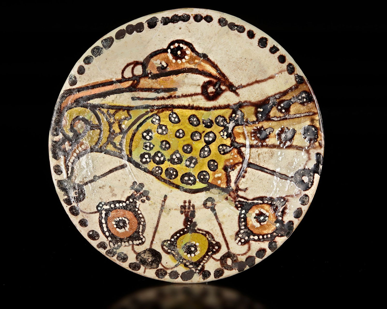 A NISHAPUR POTTERY BOWL WITH BIRD, PERSIA 10TH CENTURY: Of deep form, this earthenware bowl is coated with a white slip and decorated in black, red, and yellow staining slips beneath a transparent glaze. The interior features a large, stylized peacock with