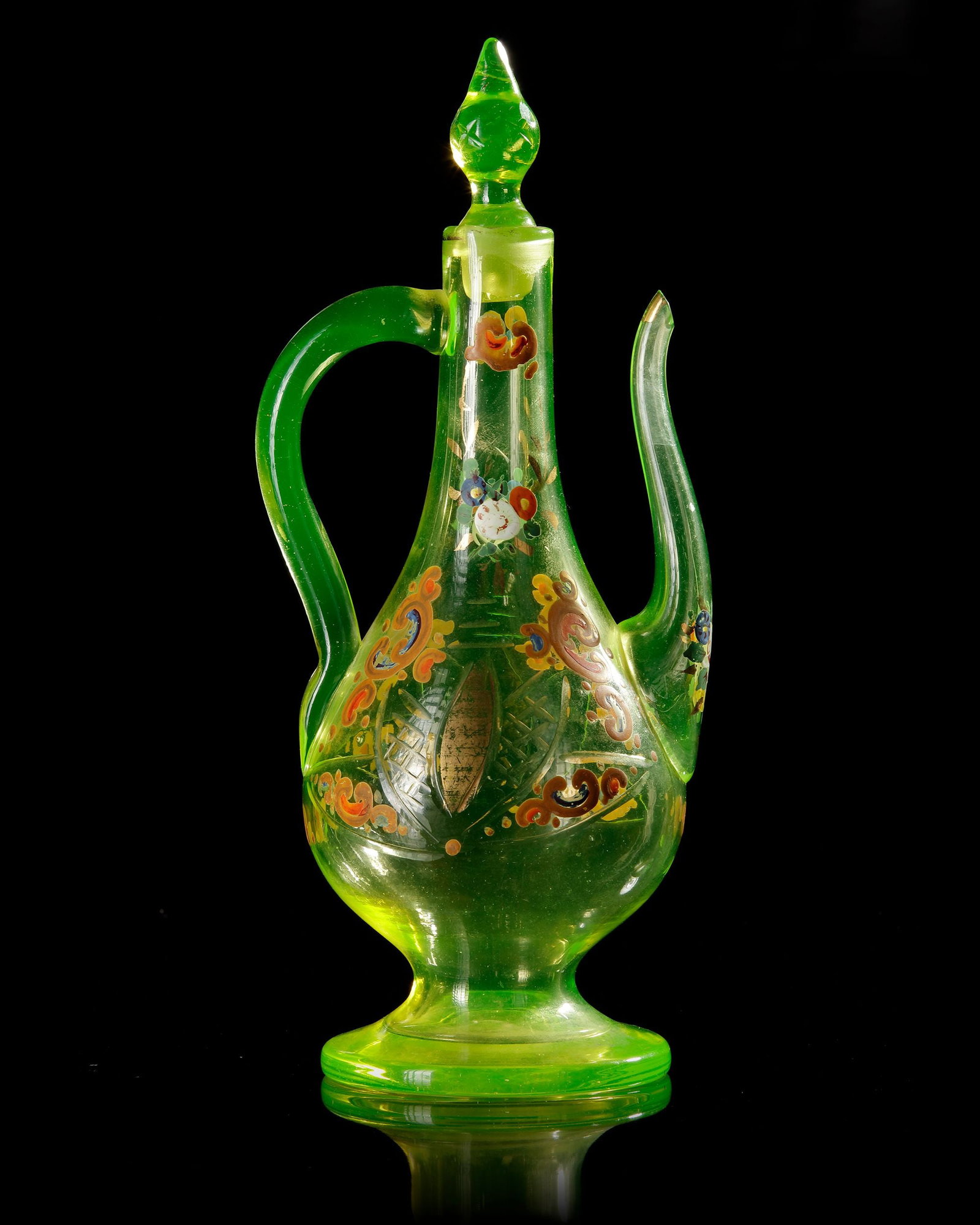 A BOHEMIAN GLASS ROSEWATER EWER, MADE FOR THE ISLAMIC MARKET, EARLY 19TH CENTURY: A tall pear-shaped body that rises from a circular foot, tapering upward into a narrow neck fitted with a pointed stopper. The vessel features a gracefully curved handle and a long, slender pouring sp