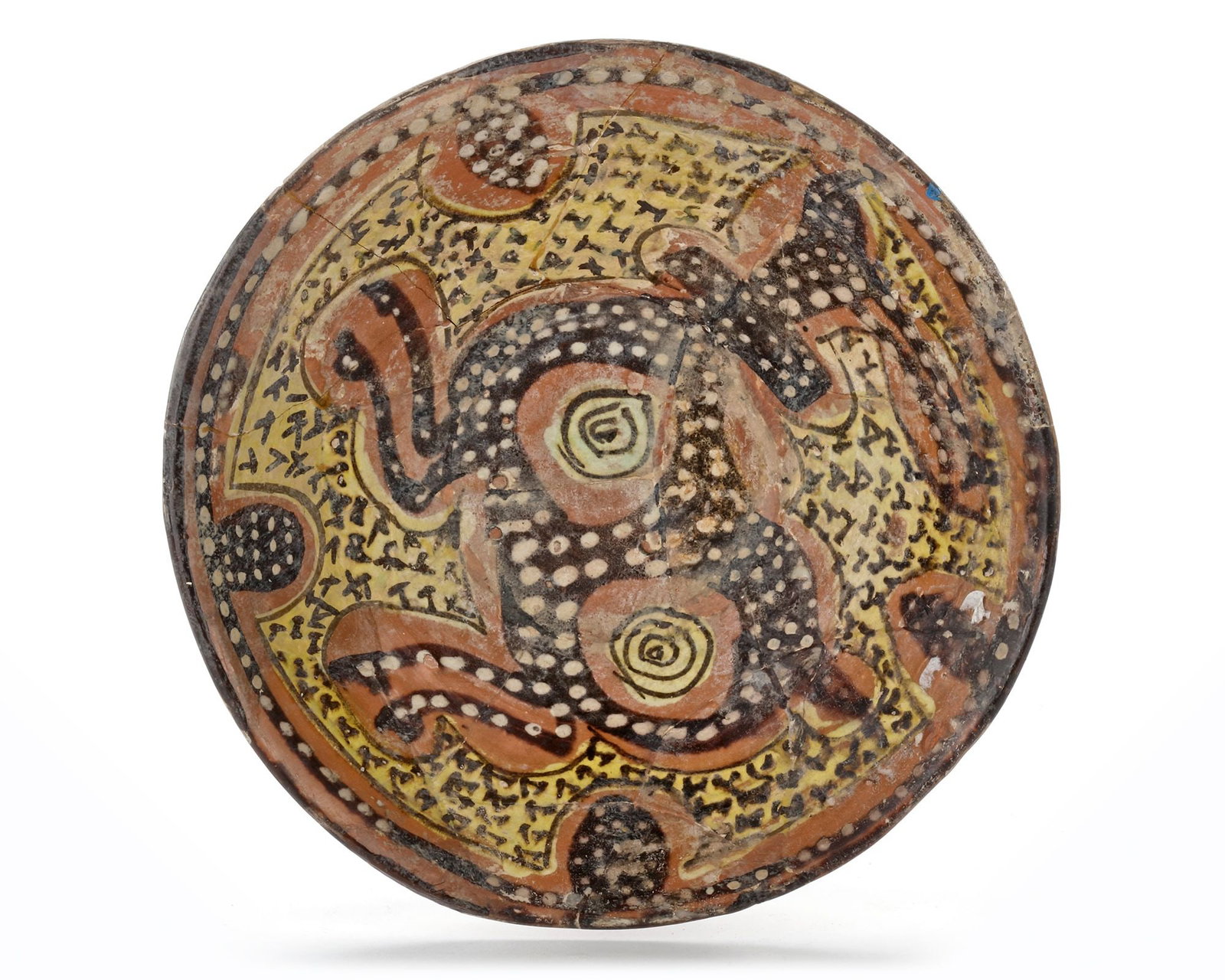 A NISHAPUR POTTERY BOWL, PERSIA, 10TH CENTURY: A Persian pottery bowl, resitng on a small foot with slightly flared sides, the reddish-slipped surface bears a painted decoration of a long-horned and hoofed quadruped ram or a composite creature. Wh