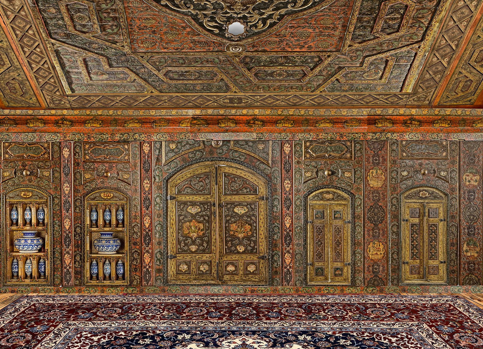 A GILT, GESSOED AND PAINTED 'DAMASCUS ROOM', OTTOMAN SYRIA, DATED 1234 AH/1818-1819 AD: A traditional Damascus reception room (qa??a) is articulated into two distinct zones: the ??ataba, a lower entrance space or antechamber, often paved in stone and occasionally centered on a fountain,