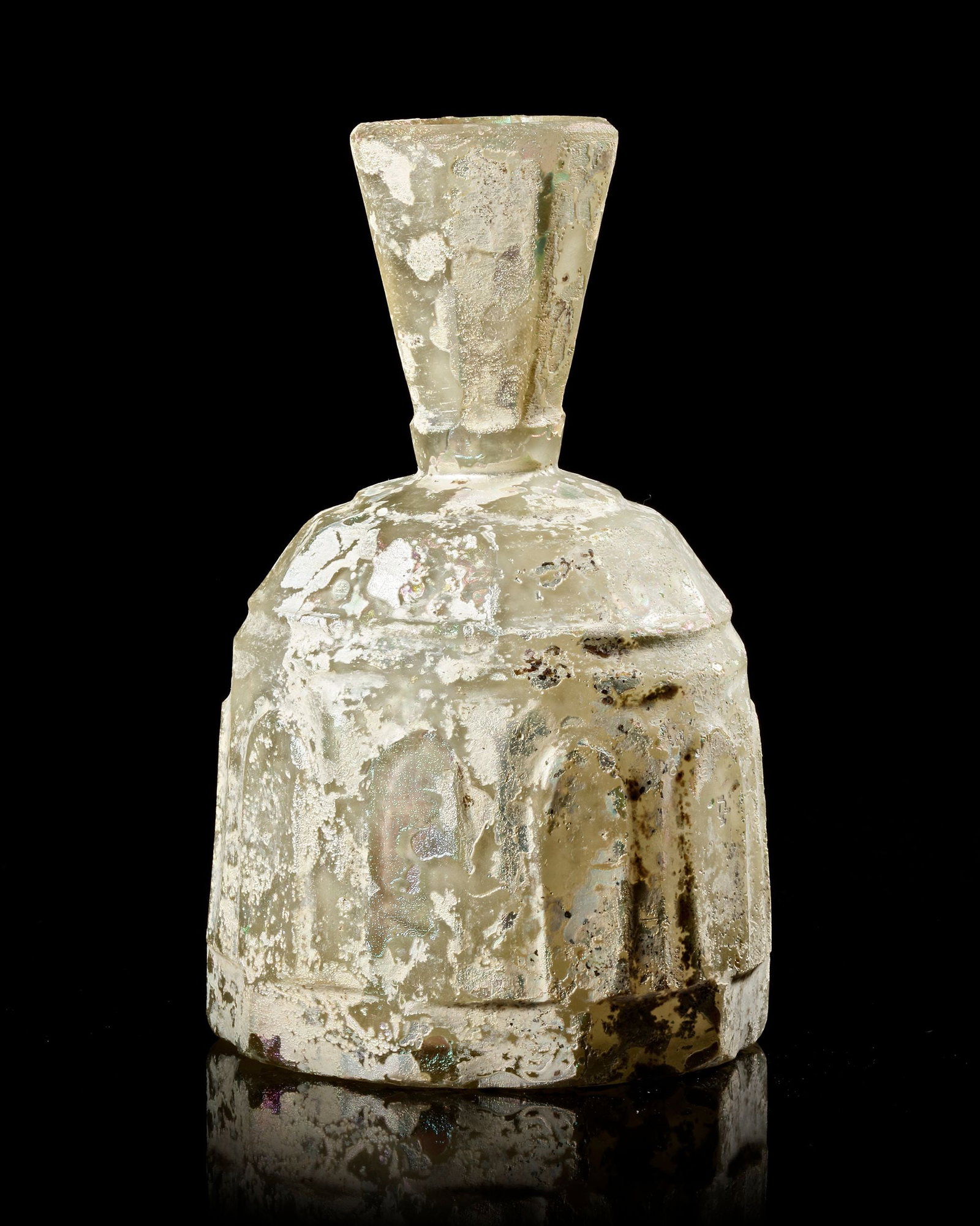 AN INTACT WHEEL-CUT CLEAR GLASS BOTTLE PROBABLY NORTH EAST PERSIA, 8TH-9TH CENTURY: Of domed form with heptagonal flaring neck, the body cut with a series of elongated arches forming an arcade, the shoulder, neck and lower body cut with a series of facets. Intact. 14 cm. high.