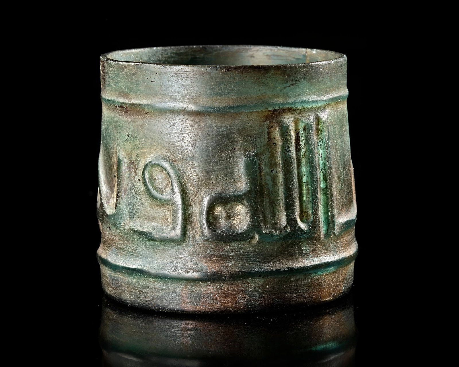 AN ISLAMIC GLASS BEAKER, NEAR EAST, 10TH-11TH CENTURY: Of cylindrical form, decorated around the body with a band of calligraphy between two rings at the rim and the base. Inscriptions: in large kufic script '' Subhan Allahi wa bihamdihi (Glory and praise