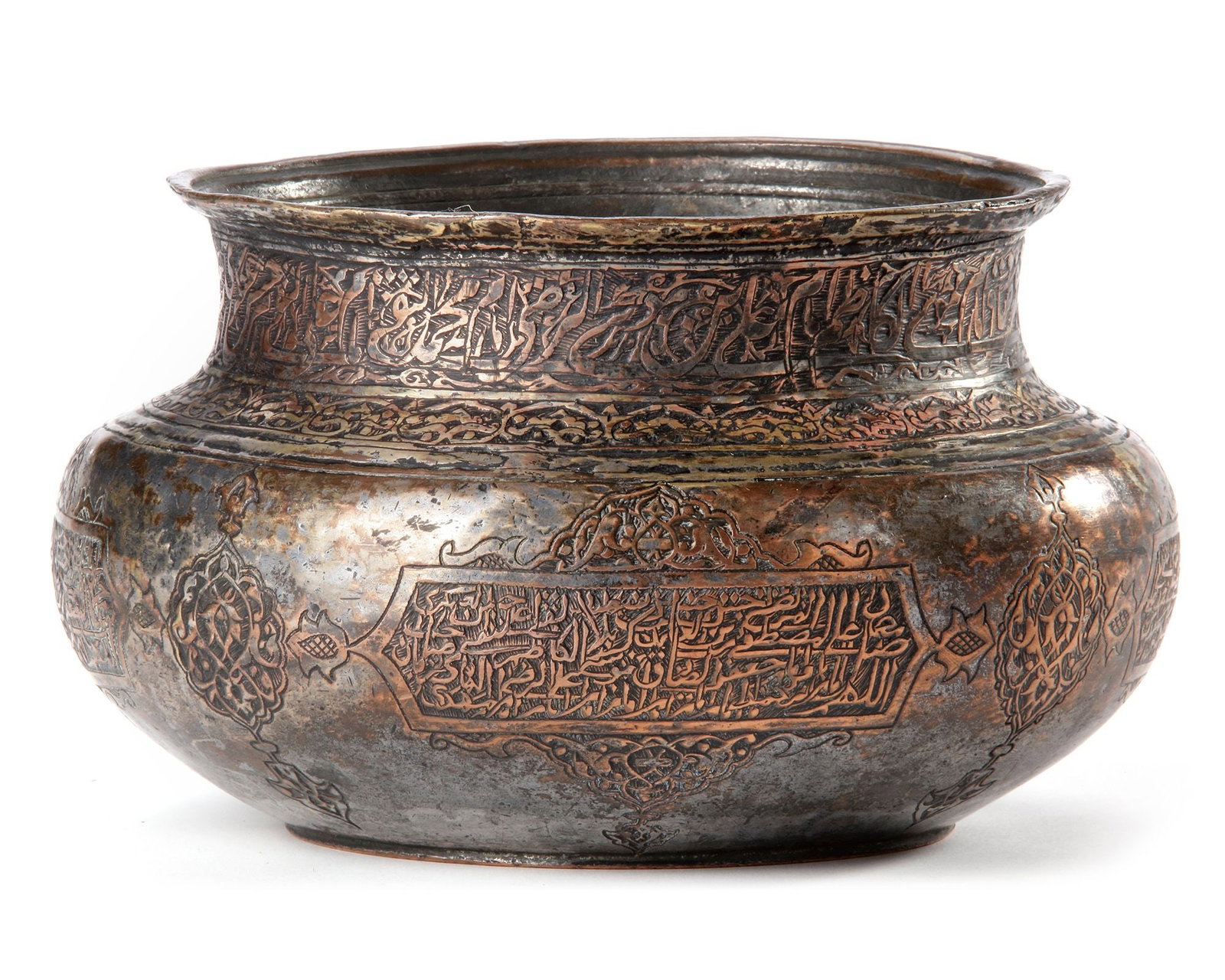 A SAFAVID TINNED COPPER BOWL, PERSIA 17TH CENTURY: A tinned copper bowl of compressed globular form, featuring a waisted neck and a gently everted rim. The body is finely engraved with inscriptions enclosed in cartouches and roundels adorned with flor