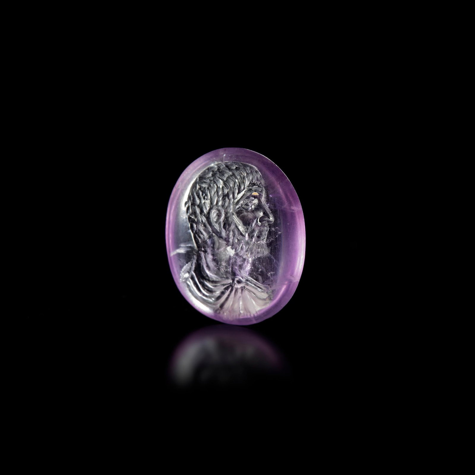 A ROMAN AMETHYST INTAGLIO PORTRAIT OF A NOBLEMAN â€“ REPUBLICAN PERIOD, EARLY 1ST CENTURY A.D.: This captivating Roman intaglio, carved in rich violet amethyst, features the finely detailed profile of a nobleman from the early 1st century A.D., during the late Republican period. The gemstone rad