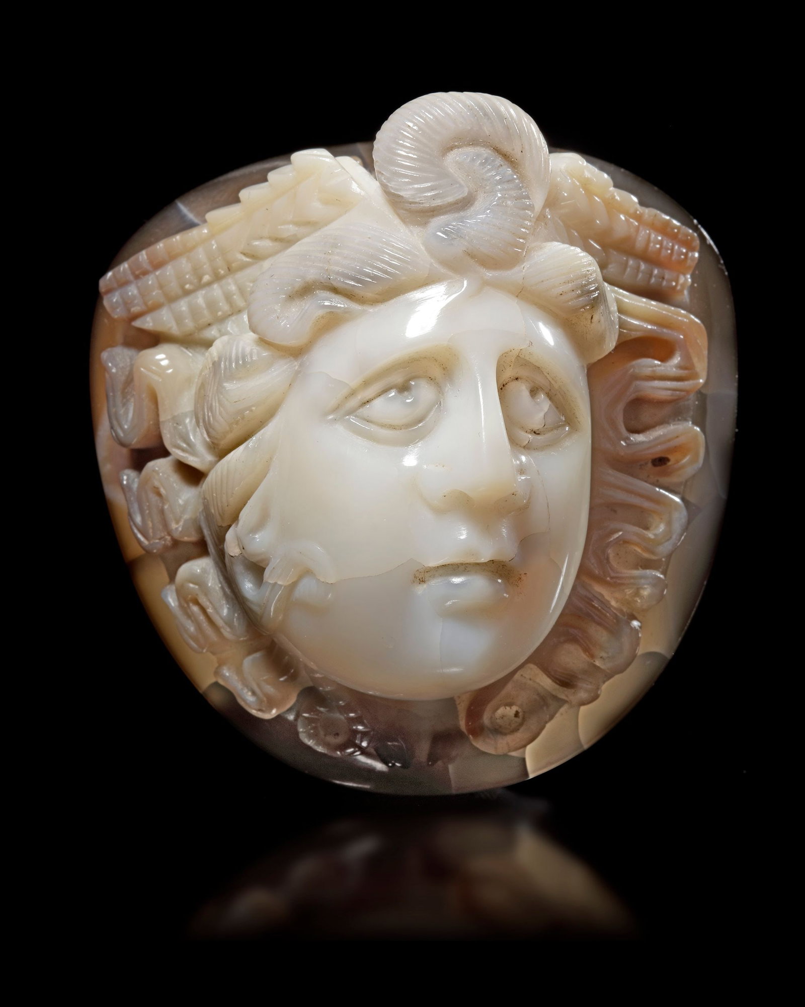 A LARGE CAMEO OF MEDUSA OF EXTRAORDINARY SIZE AND PROPORTIONS, 1ST-2ND CENTURY AD: A large cameo in agate of the head of Medusa, shown three quarters towards the left. This exceptional cameo is part of a series that is commonly found throughout the Roman Empire and represents the am