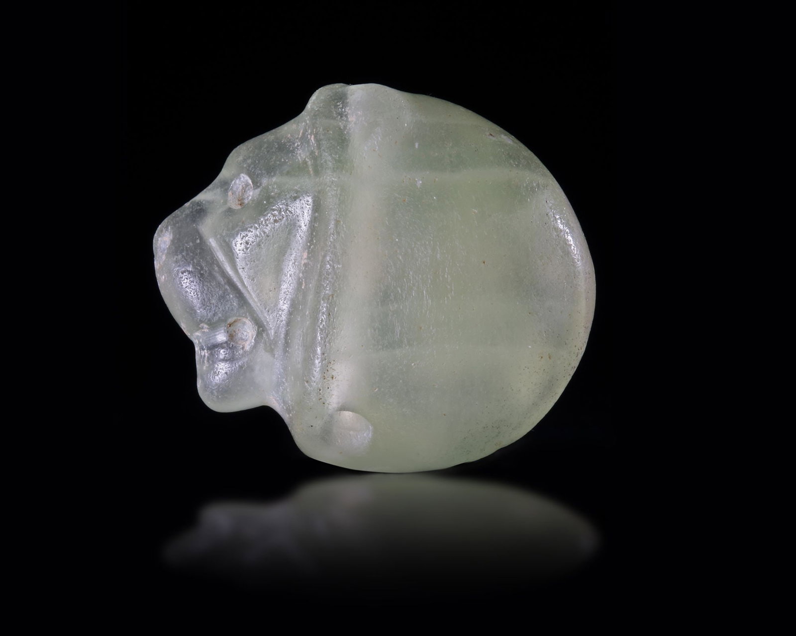 A NEAR EASTERN SEAL IN GREEN CALCITE IN THE FORM OF A LION'S HEAD, 3RD MILLENNIUM BC (1 of 3)