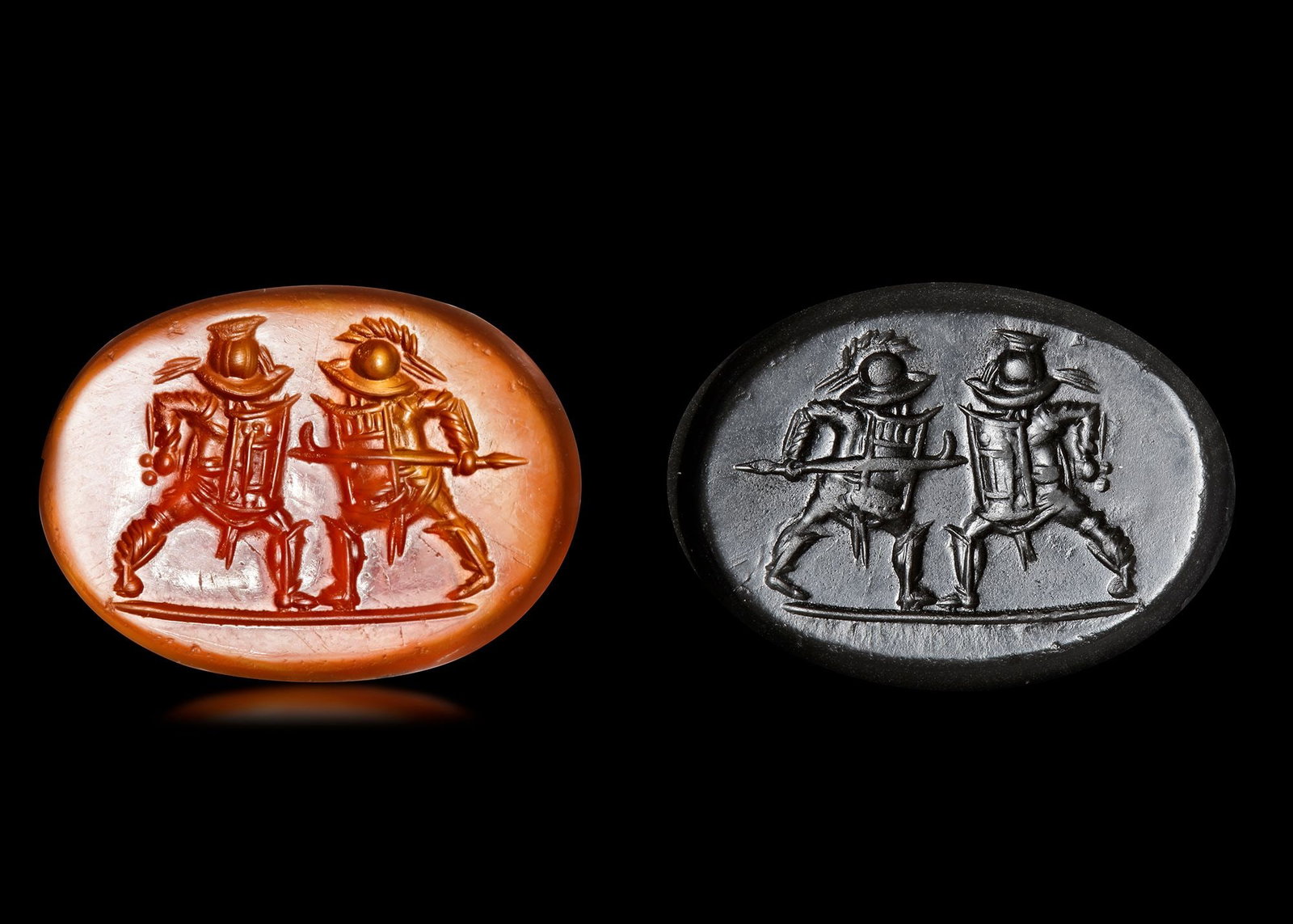 A ROMAN INTAGLIO WITH TWO GLADIATORS, 1ST CENTURY AD: An orange carnelian intaglio showing two gladiators with similar equipment engaged in combat. One holds a glade hidden behind his shield and the other has a spear with a harpe finial. 18 mm by 13 mm.P